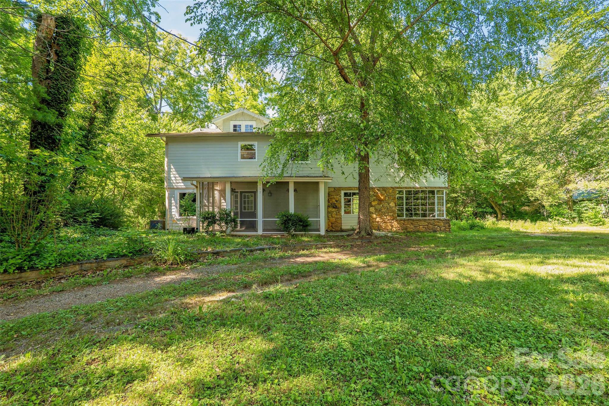 Presenting a renovated 3-bedroom farmhouse that combines historic charm, modern updates, and exceptional versatility on a rare 1.48-acre parcel just 15 minutes from Asheville. A brand-new eat-in kitchen opens to a gracious dining room with fireplace and an inviting living room featuring exposed stone walls, a second fireplace, tongue-and-groove ceiling and vintage vibe not found in  new builds. The main level also includes a laundry room, mudroom and half bath for daily convenience. Upstairs, you'll find three light filled bedrooms, original wood wainscoting, generous closets, a full bath and easy attic storage. The ample usable acreage inspires gardens,  workshop, garage or future expansion with enough parking area to accommodate multiple vehicles, trailers or RV. Move-in ready and rich with character, this rustic modern farmhouse offers space, flexibility and a relaxed lifestyle with easy access to all the amenities of Asheville and the surrounding Blue Ridge!