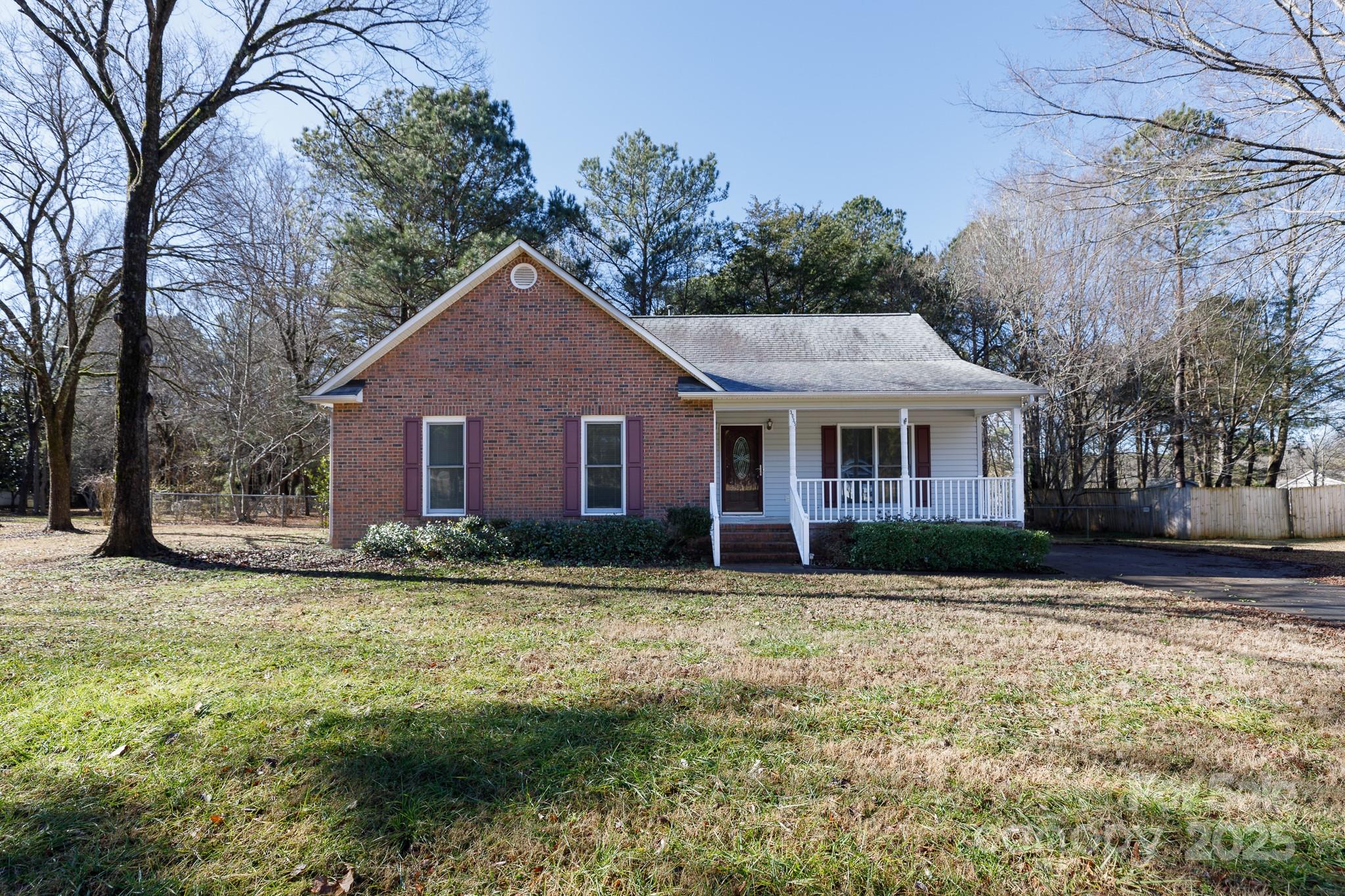 Experience the perfect balance of peaceful country living and modern convenience in this charming 3-bedroom, 2-bath ranch nestled on a full acre with no HOA and no city taxes! The inviting living room features soaring vaulted ceilings and a cozy gas-log fireplace, creating a warm and welcoming space. The well-appointed kitchen offers a breakfast bar and pantry, making meal prep a breeze. Retreat to the spacious primary suite, complete with a tray ceiling, walk-in closet, dual sinks, and a private water closet. Step outside to enjoy the brand-new deck, perfect for entertaining, or unwind on the rocking chair front porch. The fenced yard, fire pit, and storage building add even more functionality to this fantastic property. All this, while being just a short drive from schools, shopping, and dining—offering the best of both worlds!
