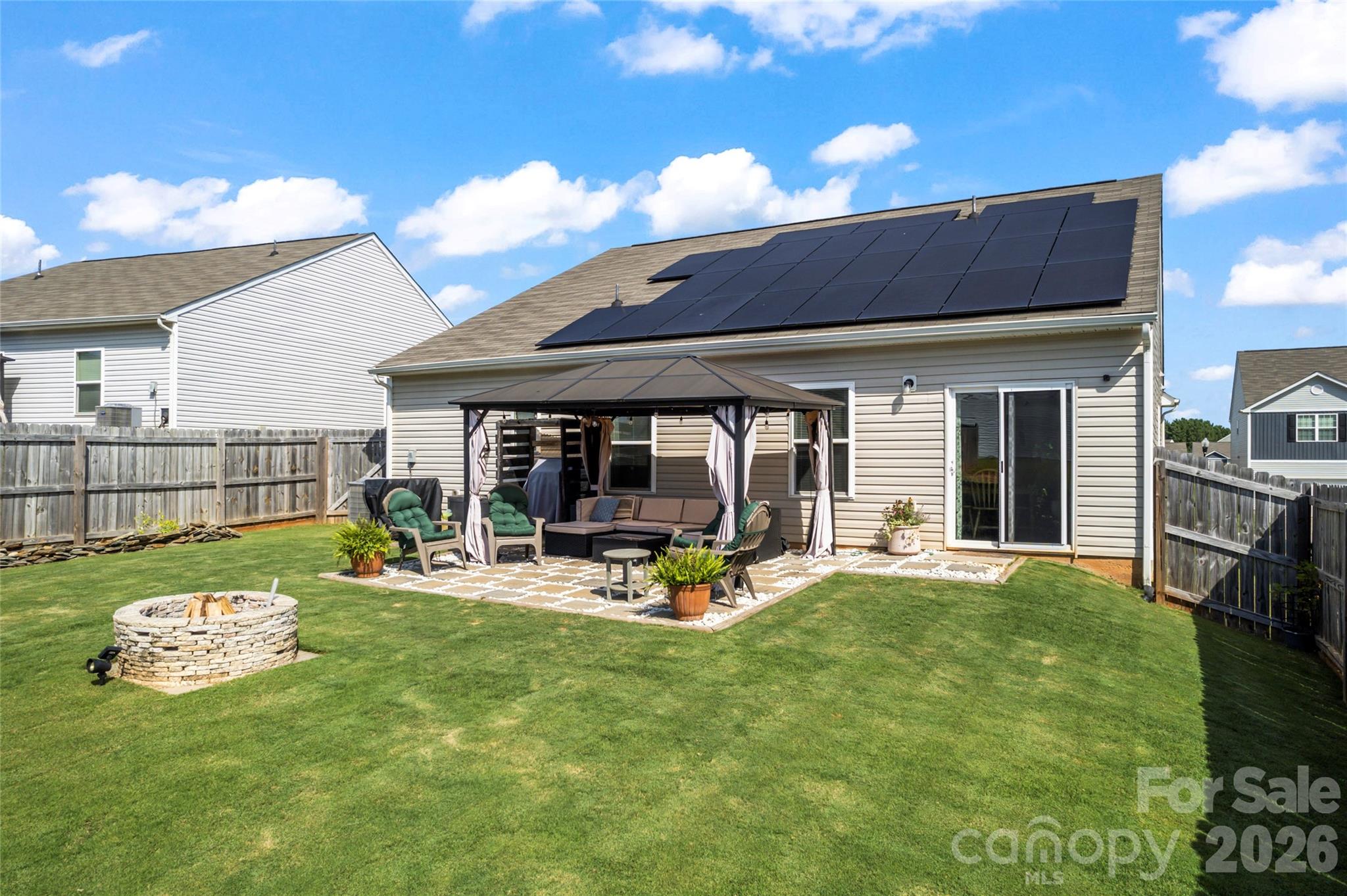WARNING: Do NOT buy this house if you absolutely hate saving money. Seriously… if lower utility bills, helping the environment, and charging your electric vehicle right in your own garage instead of donating your paycheck to gas stations sounds terrible — this home is definitely NOT for you. And those solar panels? What a nightmare… quietly producing energy, reducing monthly expenses, and potentially adding long-term value to the home. Who would want that kind of stress? Nope, this property is patiently waiting for the "bright" buyer who will truly appreciate "watt" it’s worth — both inside & out. This energy-efficient home features a solar panel system designed to deliver immediate monthly savings, with typical payments that are often lower than the average electric bill & occasionally even credit back. Enjoy the benefits of reduced utility costs from day one, along with a more sustainable lifestyle. As the loan progresses toward payoff, the system is projected to contribute an estimated $10,000–$20,000 in added resale value, making it a smart long-term investment. Combined with the home’s overall appeal, this solar advantage offers both present-day affordability and future financial upside.  If homes had personalities, this 2020 stunner would be the overachiever who shows up early, brings snacks, and still looks flawless. Featuring 3 bedrooms, 2 full baths, and a 2-car garage, this beauty checks more boxes than a moving company inventory sheet. The open floor plan flows smoother than sweet tea on a July afternoon, making it perfect for hosting, boasting, and maybe a little humble-bragging. The fenced backyard? It is ready for dogs, kickballs, grill nights, or that “accidental” second helping of burgers. Whether you’re throwing a party or just throwing a ball, this yard has you covered. Now let’s talk about the real power move… solar panels. These panels are designed to practically eliminate your electric bill. That means the only thing shocking around here is how good this deal is. Your wallet might finally get a tan from all that sunshine savings. Thinking about new construction? Why wait on dirt when this one is already dessert?  Built in 2020, lightly lived in, and dialed in. No dust. No delays. No guessing games. And yes… the price has been reduced. The sellers are motivated and ready to entertain all offers. This is not a drill. This is your sign, your signal, your flashing neon “don’t let someone else buy my house” moment. Bottom line: If you’ve been on the fence, hop off it. (This yard already has one.) Schedule the showing. Fall in love. Make the offer. Because the only thing better than dad jokes… is owning the house that comes with them.