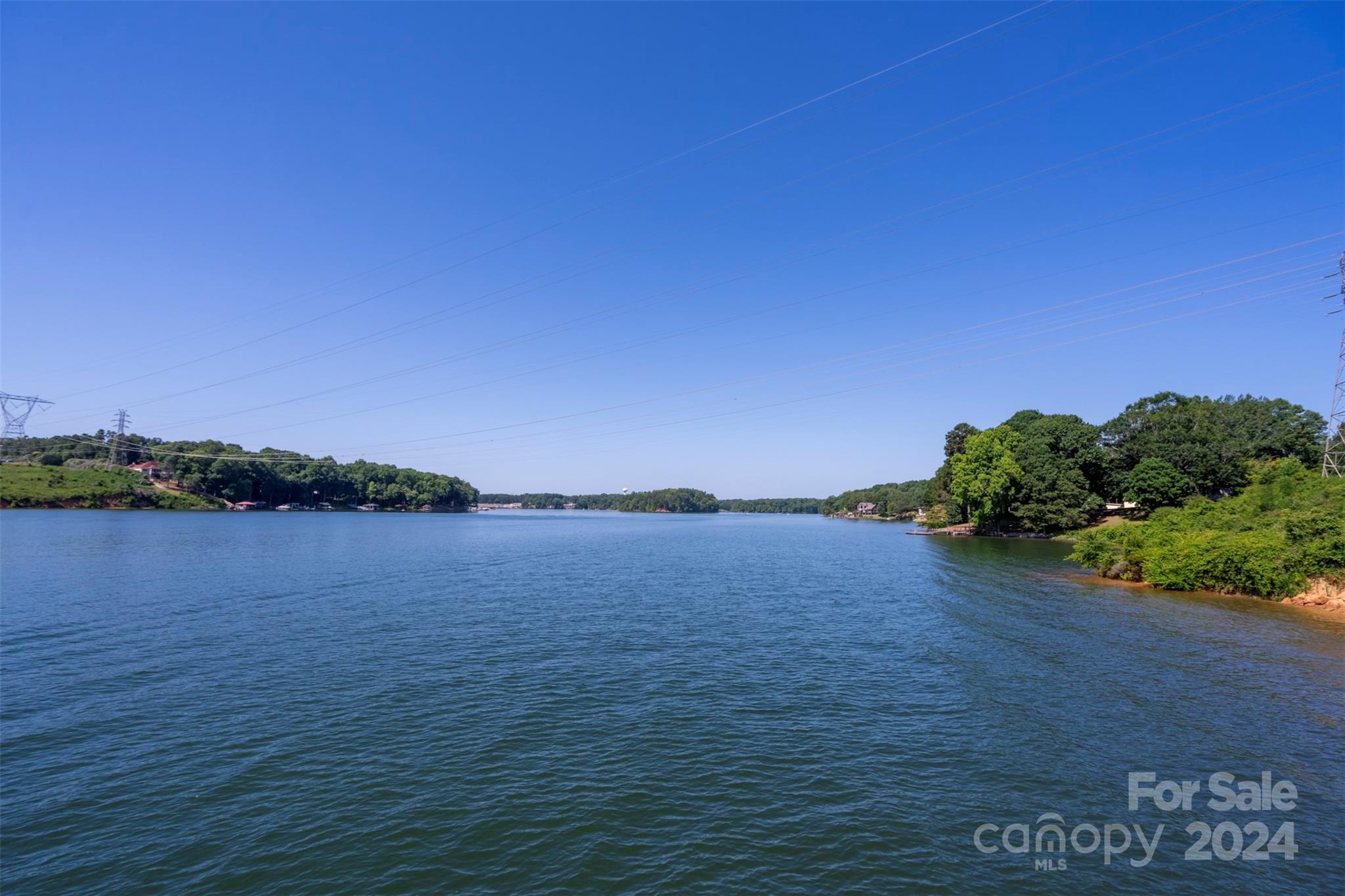 7.31 Acres  400+ feet of water frontage with Main Channel View two tiered pier with jet ski ramp  3 small cabin style buildings with bunk beds (see photos)  covered outside kitchen, outside bathroom and shower 1 acre + or- suitable for building   See building lay out.   6 + or - acres are under power line    Very unique property  with many possibilities