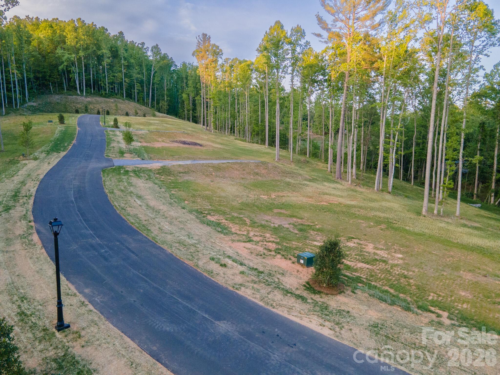 Homesite Three at Harris Cove is one of the most expansive parcels in the community, about 1.04 acres in all. The driveway is already installed on engineered fill, so that early, often involved site cost is complete and off the buyer's plate from day one. Set off the private community road and well away from public traffic, the lot sits quietly among its surroundings. Southern exposure brings strong potential for passive-solar design, subject to the buyer's architect, with abundant natural light through the year. A proposed home design by Tykke Homes is available for this homesite, with more information upon request; the design is intended to meet the community's architectural guidelines and reflects the quality and detail expected at Harris Cove.