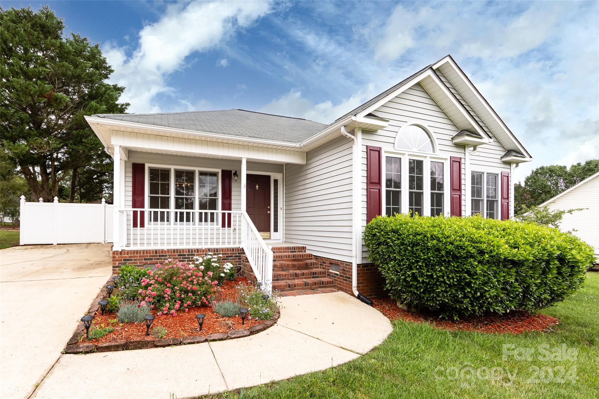 Simply adorable 3 bedroom/2 bath home with no HOA! Freshly painted one story home features gorgeous wood floors, formal dining and a sunroom. Vaulted ceiling in the great room with cozy fireplace. Breakfast area overlooks the beautifully landscaped private backyard. Primary suite has large bathroom and great closet space.
Huge picture window in the second bedroom lets in all the natural light. Kick back and relax on the inviting front porch. Outbuilding in the backyard does convey.