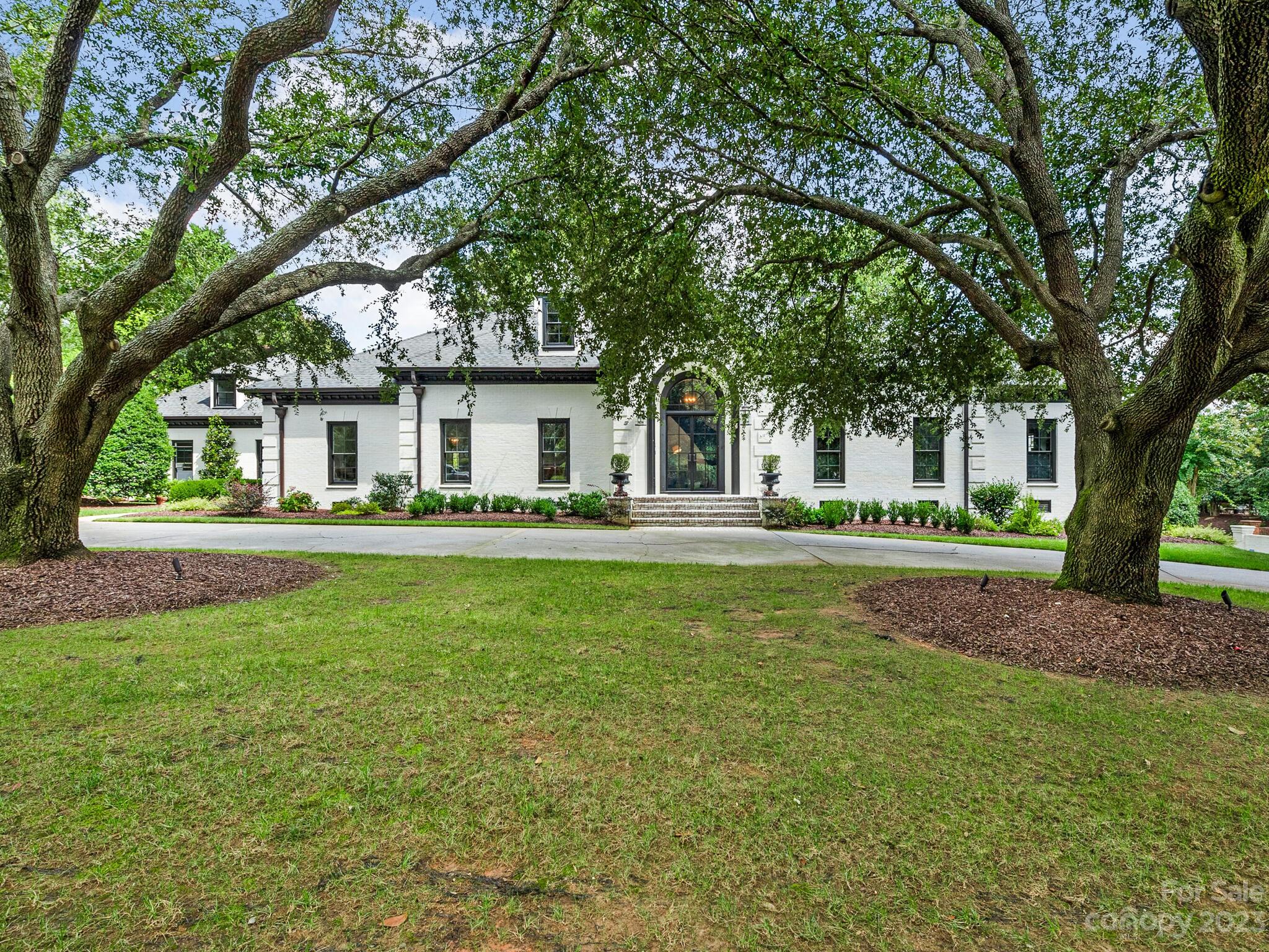Beautifully updated painted brick home located in the gated community of Seven Eagles, adjacent to Quail Hollow Club. 24 hour security, private lot with .77 acres and circular drive. Ten foot ceilings, grand foyer, and incredible molding, wainscoting, judges paneling & coffered ceilings throughout. The primary, located on the main floor, is exquisite. Large walk-in closet, 2 water closets with heated Toto seats. Guest BR is currently being used as a gym, has ensuite bath. The study has custom bookshelves and could be used as additional bedroom. Large den/family room has a beautifully designed wet bar, floor to ceiling glass wine display and gas fireplace. Kitchen has an abundance of cabinetry & high end appliances, quartz countertops and eat-in breakfast room. The bonus room has a separate staircase, wet bar & built in bookshelves. Large walk in closets throughout. 2 walk in storage areas, 3 car garage, copper gutters.