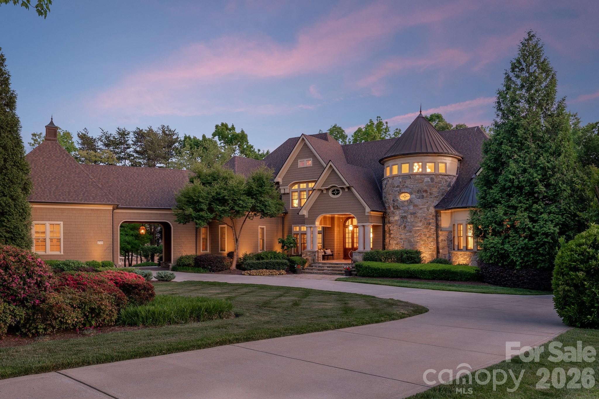 Welcome to 155 Union Chapel Drive, a timeless traditional estate offering a rare combination of scale, privacy and unmatched quality. Set along an extraordinary lot within The Point at Trump National Golf Club Charlotte, this custom waterfront estate offers 526 feet of shoreline. Thoughtfully designed by architects Christopher Phelps and Emily Bourgeois and built by Simonini Homes, the home is defined by its exceptional main-level living—offering approximately 5,000 square feet designed for both everyday comfort and effortless entertaining. A main-level walkout leads to a covered outdoor living area with pool, spa, and fireplace which is well suited for both entertaining and everyday living. The stately foyer impresses you immediately with the sweeping spiral staircase, marble flooring and detailed millwork. The lake views stay with you as with as you take in the character of the walnut flooring, custom cabinetry, detailed molding, and seven fireplaces. Designed with both function and style in mind, the kitchen is a standout feature, anchored by a 60-inch Wolf range with a custom copper hood, double islands and a separate scullery ideal for hosting and prep. The main level also includes a great room with cathedral ceilings, a charming sunroom with expansive views, two powder rooms and a private office. Lastly, the first floor owners retreat provides unmatched privacy and a true spa-like retreat. The upper level has three expansive bedroom suites, a bonus room with wet bar, a charming family room with fireplace and lake views and an additional office space. The lower level exudes quality with a mahogany custom bar and wine room and is made to be enjoyed. A 2.5-car attached garage is complemented by an additional two-car garage connected by a porte-cochère. Built to a Five-Star Energy Rating, the home includes Icynene spray foam insulation, Kolbe & Kolbe windows and doors, a newer roof with copper accents, extensive stonework, and recent interior and exterior painting. A rare offering defined by thoughtful design and a level of traditional craftsmanship that is increasingly hard to find.