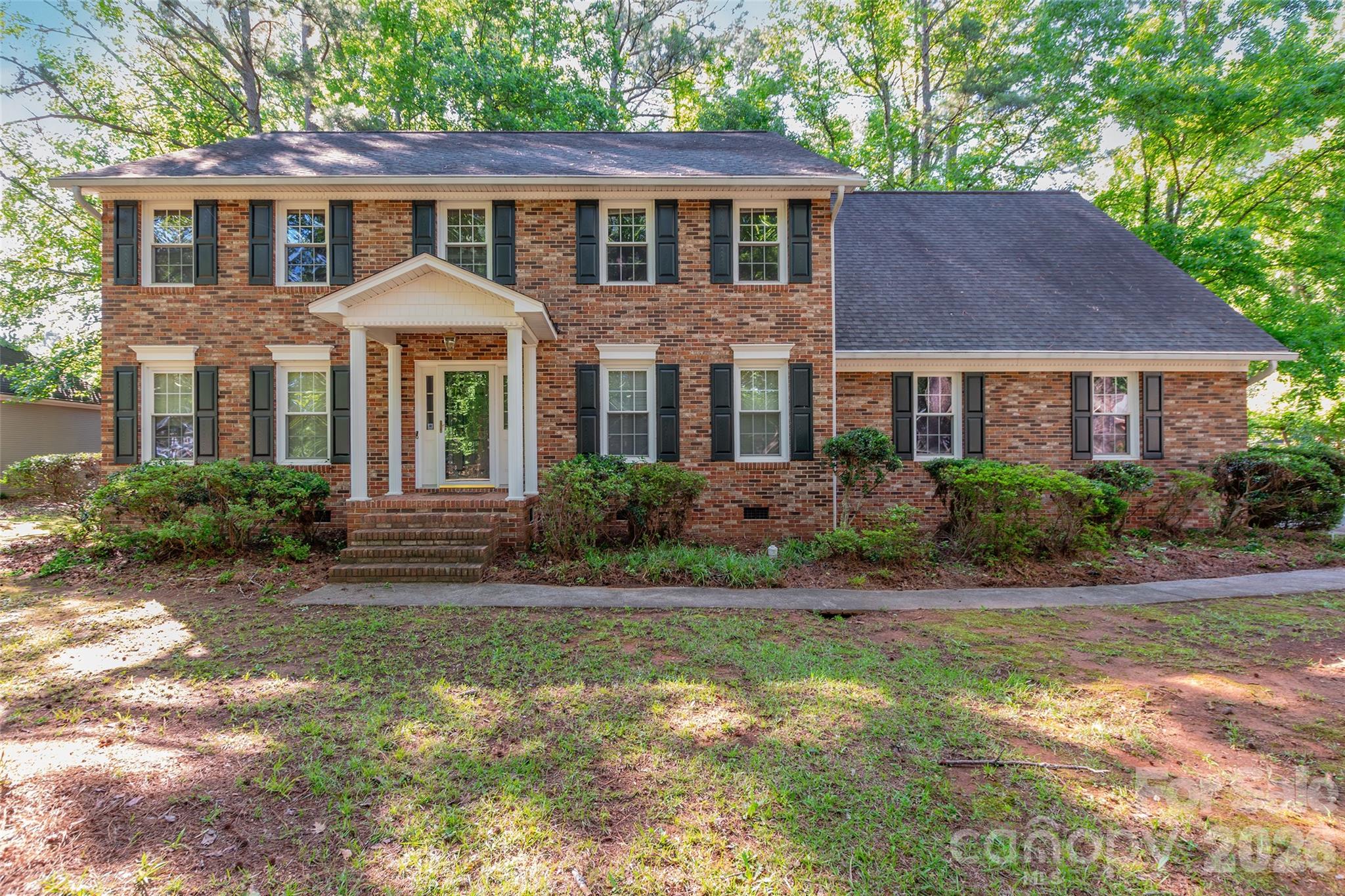 Welcome to this stunning home with exceptional curb appeal and a desirable side-load garage. Nestled on a beautifully wooded lot, this 4-bedroom, 2.5-bathroom residence greets you with a grand front staircase, a two-story foyer, and gleaming hardwood floors.  

The spacious main level features a cozy living area anchored by a classic brick and stone fireplace. The living space flows seamlessly into a large kitchen equipped with expansive counter space, a generous breakfast bay, and a massive walk-in pantry.   

For ultimate convenience, a second back staircase leads directly up to a massive bonus room. Upstairs, the primary suite has a deep walk-in closet and a spa-like en suite bathroom featuring a garden tub and separate shower. Three additional spacious bedrooms offer ample closet space and excellent layout flexibility. Step outside to enjoy peaceful mornings or relaxed evenings on your private, screened-in back porch overlooking a serene, tree-lined backyard.