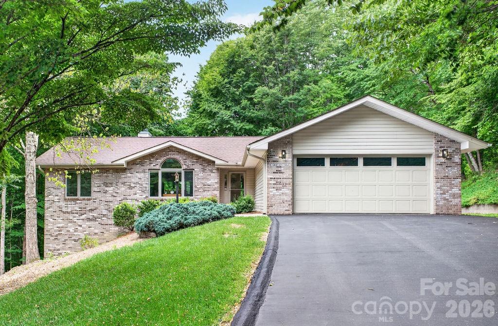 Tucked away on a private, wooded half-acre lot in highly sought-after Cummings Cove Golf & Country Club, this beautifully maintained home offers main-level living with an expansive walk-out lower level, workshop, and storage. The main level living offers a bright, open floor plan features vaulted ceilings, custom arched windows, new skylights (2025), new hardwood floors (2025), and a floor-to-ceiling stone gas log fireplace with a custom wood mantel. The adjoining three-season room provides additional living space and opens to a spacious Trex deck overlooking the natural mountain setting. The kitchen is designed for both functionality and entertaining, offering granite countertops, upgraded custom cabinetry, stainless steel appliances including a five-burner gas range, two pantries, and a breakfast nook with beautiful views. The primary suite features deck access through sliding doors, a walk-in closet, and a spacious bath with double vanity and large glass-enclosed shower. A split-bedroom floor plan provides privacy for guests, with two additional bedrooms and a full bath separated by a pocket door. The main-level laundry room includes cabinetry and a utility sink. An oversized side-entry two-car garage with opener completes the main level. The walk-out lower level offers exceptional flexibility with a large recreation or family room, wet bar, second gas log fireplace, two additional bedrooms, a full bath, large workshop space, and abundant storage. A covered patio extends the living area outdoors and creates an ideal setting for relaxing or entertaining. New HVAC 2025. Nestled in the Blue Ridge Mountains, Cummings Cove Golf & Country Club is more than a gated community—it is a vibrant lifestyle community with resort-style amenities and a full social calendar. The monthly HOA dues of just $180 include access to a heated pool and spa, water aerobics, fitness center and fitness classes, tennis, pickleball and clinics, bocce ball, dog park, community garden, numerous clubs and activities, and on-site dining and bar service at the clubhouse. Golf is available year-round with play & membership optional. Just beyond the gates, you'll find some of Western North Carolina's most desirable destinations. DuPont State Recreational Forest and Pisgah National Forest are only minutes away, offering endless opportunities for hiking, waterfalls, biking, fishing, and outdoor adventure. Hendersonville and Brevard are approximately 20 minutes away and provide excellent shopping, dining, healthcare, entertainment, and seasonal festivals. Everyday conveniences including groceries, gas, and local restaurants are just minutes away in Etowah and Horse Shoe, while Asheville Regional Airport is conveniently located about 20 minutes from the community. Some furnishings are negotiable. Personal property that will convey with the sale: Basement-couch, chair & ottoman, dining table & 6 chairs. Basement bdrm- bed, dresser & nightstand. Dehumidifier. Breakfast nook table & chairs. Kitchen refridgerator. washer & dryer (dryer new 2025).