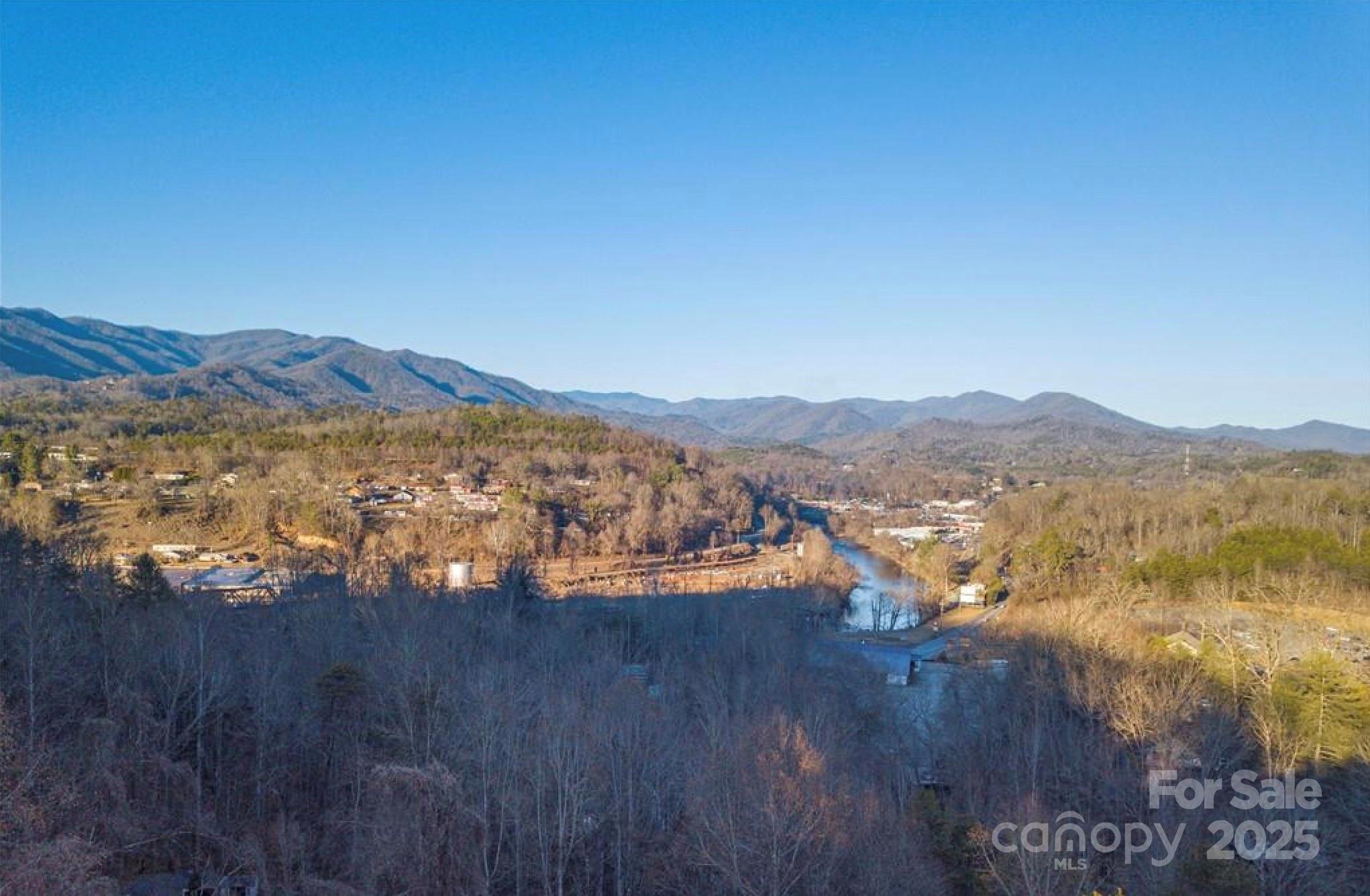 .25 acres near downtown Bryson City with city water and sewer. Limited restrictions: no livestock, no metal siding or roofing. Dirt road access, off paved public road. Seller financing is available.