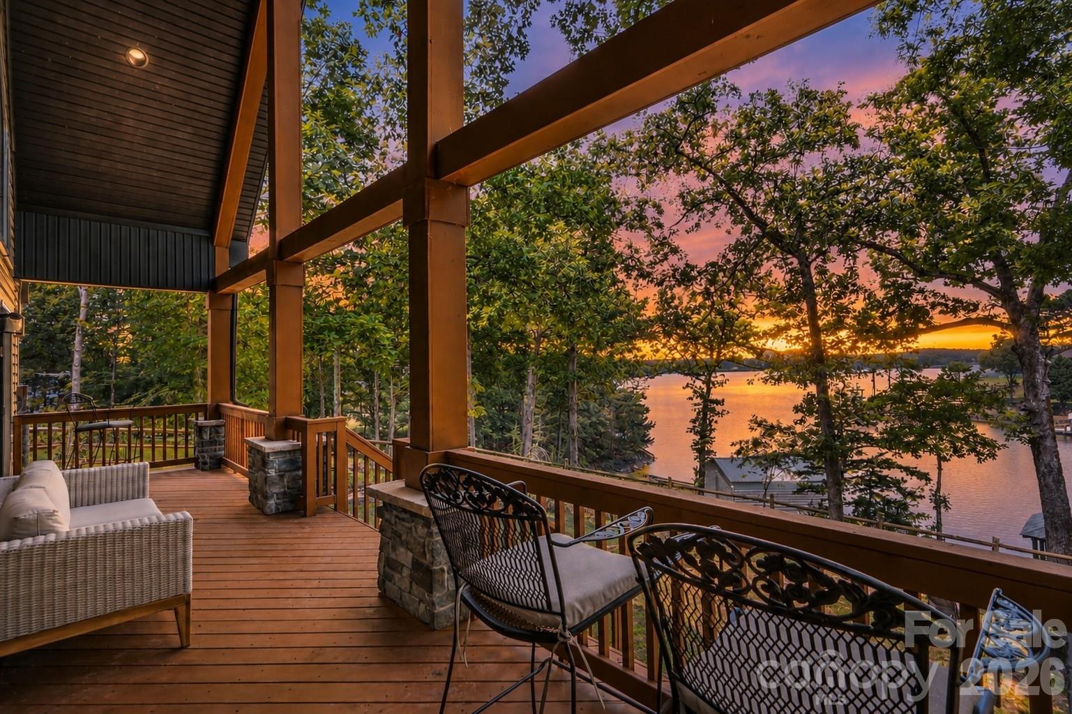 Peaceful waterfront retreat nestled on a beautifully wooded lot in a protected cove with breathtaking main channel views. This exceptional home offers year-round lake living with the relaxed feel of a private vacation getaway. The open floor plan showcases vaulted ceilings, beautiful flooring, and soaring windows that fill the home with natural light while framing the picturesque water views. The inviting great room flows seamlessly into the dining area and well-appointed kitchen, creating the perfect space for everyday living and entertaining. The kitchen features granite countertops, stainless steel appliances, a breakfast bar with ample seating, and a pantry. The spacious main-level primary suite offers dual vanities, a large walk-in shower, and a walk-in closet. Upstairs, you'll find an additional bedroom, full bath, and versatile flex room ideal for a home office, guest space, or hobby room. Step outside to experience the best of lake living. Enjoy peaceful mornings and spectacular sunsets from the covered deck, host family and friends on the expansive entertaining deck, or spend endless days on the water from the covered dock complete with a seating area and boat lift. A detached two-car garage provides additional storage for vehicles and lake toys. Conveniently located just minutes from shopping, dining, and everyday amenities, this waterfront gem offers the perfect balance of privacy, tranquility, and easy access to everything you need.