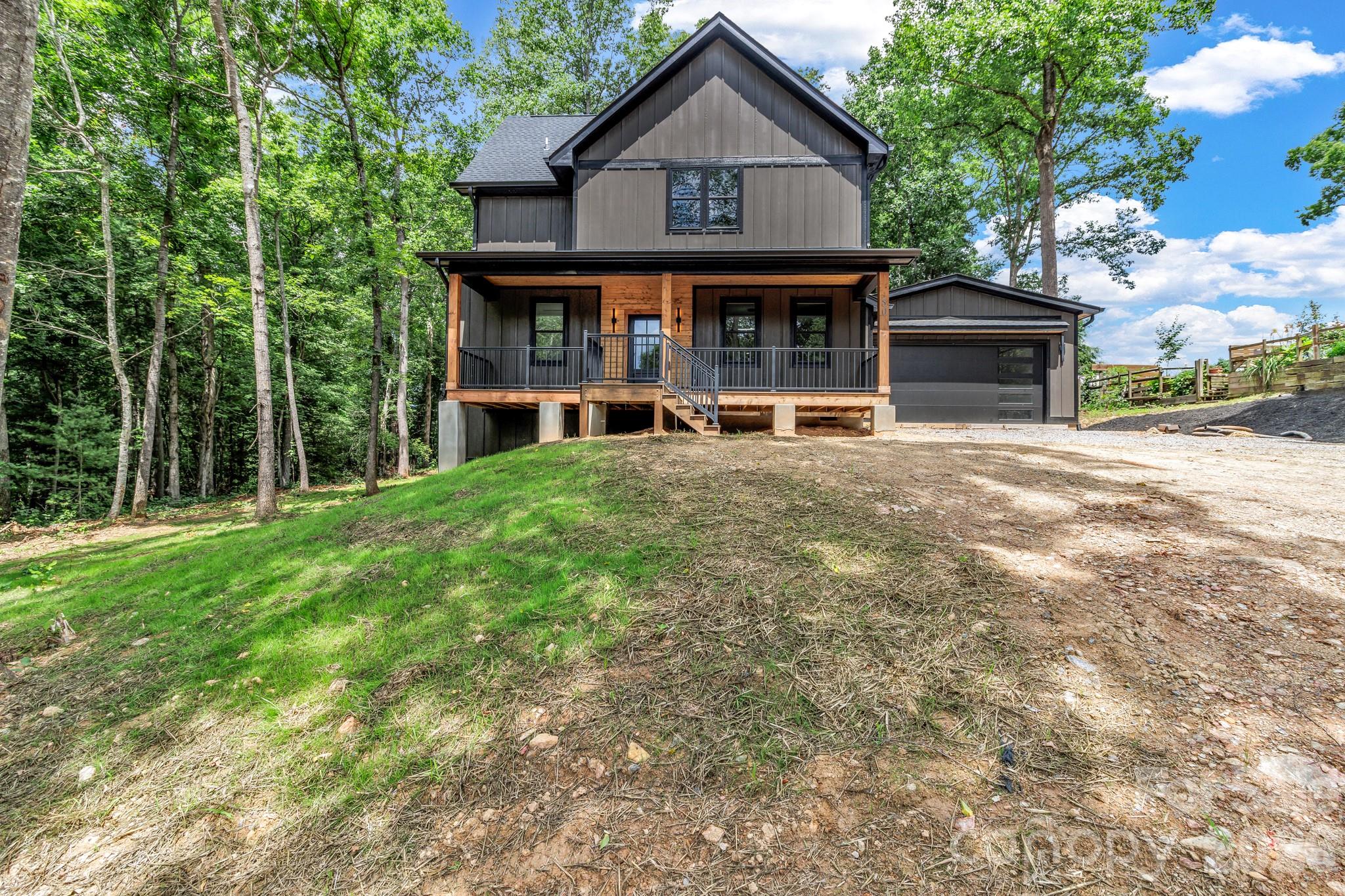 Experience the perfect blend of modern luxury, privacy, and convenience in this stunning new construction home offering over 2,300 square feet of thoughtfully designed living space. Situated on nearly an acre at the end of a private road, this property offers exceptional privacy with no HOA or restrictions while overlooking over 180 acres of NC State University farmland.

The main level features a spacious open-concept floor plan designed for both everyday living and entertaining. The inviting living room is centered around a beautiful gas fireplace and flows seamlessly into the kitchen, which showcases quartz countertops, stainless steel appliances, custom cabinetry with under cabinet lighting, and abundant storage. The primary suite is conveniently located on the main level and features a spacious bathroom with a walk-in shower, dual vanities, large walk-in closet, and its own laundry room. The bedroom also offers private access to the covered back porch, providing the perfect place to relax and enjoy the peaceful farmland views.

Upstairs, you'll find two generously sized bedrooms, a bonus room that could easily serve as a fourth bedroom, and a second laundry room for added convenience. One bedroom features its own private bathroom and walk-in closet, while the other offers access to a private balcony overlooking the surrounding countryside.

Complete with 3.5 bathrooms, a 2-car garage, and quality finishes throughout, this exceptional home offers the rare combination of privacy and accessibility. Conveniently located off Brevard Road across from High Vista, you'll enjoy easy access to Asheville Regional Airport, Biltmore Park, shopping, dining, and all that Western North Carolina has to offer.