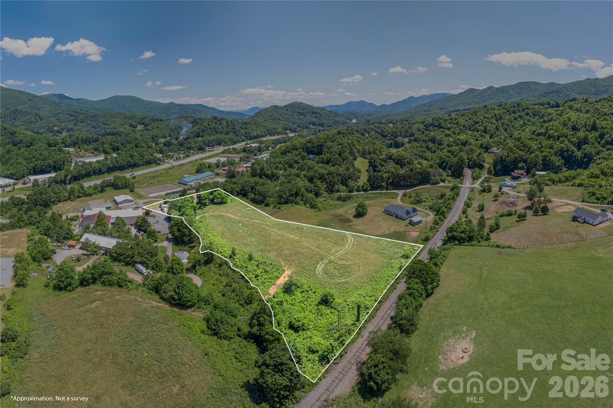 Prime Development Opportunity in Waynesville
Exceptional opportunity to acquire nearly 6 acres of highly visible and accessible property along the Great Smoky Mountain Expressway, just minutes from downtown Waynesville. Offering breathtaking long-range mountain views in every direction, this unique property combines location, utility, and redevelopment potential in one remarkable package.
The property features a large historic apple processing warehouse, an additional garage/shop building, and expansive usable acreage with gently rolling topography that lends itself to a wide variety of commercial, mixed-use, residential, or investment-oriented projects subject to zoning. The land lays exceptionally well, providing flexibility for future development while maximizing the stunning mountain vistas that surround the site.
With direct exposure to one of the area’s primary transportation corridors, the property benefits from excellent visibility and convenient access, making it an ideal candidate for businesses seeking a prominent location or developers looking to capitalize on Waynesville’s continued growth. 
The historic warehouse structure offers substantial square footage and character, presenting an opportunity for restoration, adaptive reuse, storage, barn, event space, artisan production, or other creative redevelopment concepts. While the building requires renovation, its scale and history provide a unique foundation for a visionary project.
Infrastructure advantages include an existing well, available public water connection, and natural gas access, adding significant value and development flexibility. Whether you’re seeking a commercial headquarters, residential development site, mixed-use project, mountain retreat, or investment property, this versatile tract offers endless possibilities in one of Western North Carolina’s most desirable locations. Endless possibilities, unmatched views, and a strategic location make this a truly unique Western North Carolina offering.