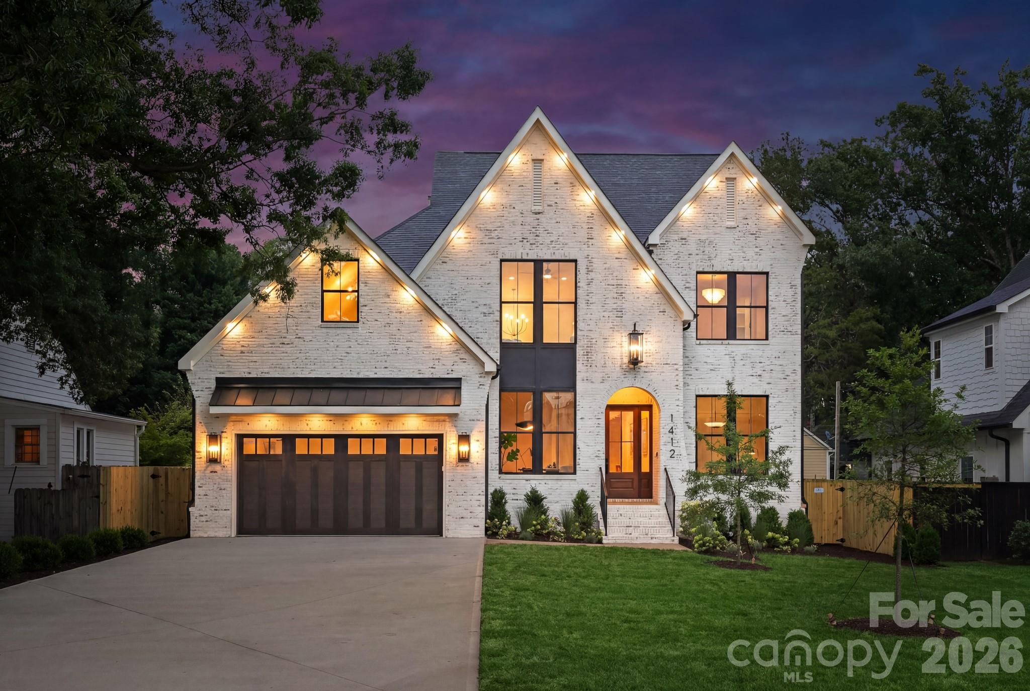 Located in Plaza Midwood, this luxury new construction home offers five bedrooms, flexible living spaces, and a level of finish rarely found at this price point, all within one of Charlotte's most vibrant and walkable neighborhoods. With soaring 10-foot ceilings on the main level, designer light fixtures throughout, and an exceptional outdoor living space, every inch of this home reflects an uncompromising commitment to quality craftsmanship and design. 

A dramatic arched entryway opens to the main level, where a private office, a guest bedroom with flexibility to serve as a secondary office, and a full bathroom offer immediate versatility. The living room anchors the main floor with a gas fireplace, custom built-ins, and sliding glass doors that open seamlessly to the covered patio.

The kitchen impresses at every turn, featuring a dual gas range and oven, microwave drawer, cabinet-ready refrigerator, and KitchenAid appliances, all complemented by Taj Mahal quartzite countertops and full-slab backsplash. A waterfall island with seating for five to six, glass display cabinetry with integrated lighting, and toe-kick accent lighting add warmth and architectural depth. The walk-in pantry features an additional prep sink, wine cooler, and built-in shelving to keep everything close at hand and beautifully organized.

The main-level primary suite is a private retreat with a Venetian plaster accent wall, gas fireplace, and a spa-caliber bath featuring a freestanding soaking tub, glass shower with rain head, and a primary closet with floor-to-ceiling custom shelving and dedicated washer and dryer connections.

Upstairs, three additional guest bedrooms each offer walk-in closets with custom built-in shelving and clothing racks. Two full bathrooms serve the upper level, including a Jack-and-Jill bath with dual vanities, soft-close cabinetry, Taj Mahal counters, and a glass-enclosed shower, while a second full bath offers a shower and tub combination with equally refined finishes. A vaulted bonus room, an open loft ideal for a secondary lounge or home office, and a spacious laundry room with floor-to-ceiling cabinetry complete the upper level with room to live, work, and unwind. Designer lighting, soft-close cabinetry, and gold hardware carry a consistent, elevated aesthetic throughout every space. Thoughtful lighting details, including dimmable toe-kick lighting, under-cabinet lighting, and shower niche lighting, add a refined finishing touch throughout.

Outside, the fully fenced backyard is spacious and private, finished with professional landscaping. The covered patio features an additional gas fireplace and designer sconces, making it a true extension of the home. An oversized two-car garage with soaring ceilings provides ample room for vehicles and additional storage. 

A four-zone HVAC system ensures comfort is tailored to every level and living space, while a tankless gas water heater supports efficient, on-demand performance throughout the home. 

Tucked into a tranquil tree-lined neighborhood just off Central Avenue, this home is within walking distance to Plaza Midwood's best dining, retail, and nightlife, as well as Veterans Park. It also provides a short commute to Uptown and SouthPark, quick connectivity to E. Independence Boulevard, and proximity to some of Charlotte's top-rated public and private schools.