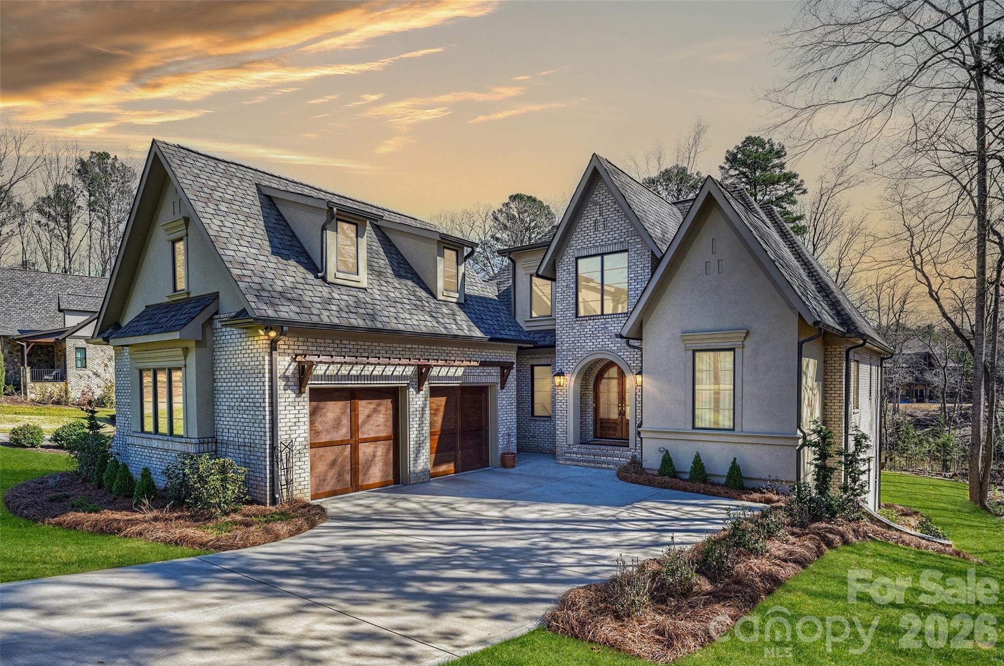 One of the newest and most thoughtfully designed homes in Reflection Pointe, this custom residence offers over 5,000 square feet of luxury living, exceptional craftsmanship, and a private setting within one of Belmont's most sought-after gated communities. Designed for everyday comfort and effortless entertaining, the home blends sophisticated architecture, resort-style amenities, and access to the Lake Wylie lifestyle, all just minutes from charming downtown Belmont.  Crafted by the award-winning team at Vinyet Architecture, the home showcases a seamless balance of modern elegance and functional design. Expansive windows fill the interior with natural light, highlighting thoughtfully curated finishes and architectural details throughout.   At the heart of the home, the chef's kitchen features custom cabinetry, an oversized island, professional-grade appliances, integrated refrigerator and freezer columns, and a scullery pantry with beverage center. The kitchen flows effortlessly into the dining area, great room, and inviting den with fireplace, while multiple outdoor living spaces create a natural connection to the surrounding landscape.   The main-level primary suite serves as a private retreat, complete with outdoor access, a spa-inspired bath featuring a freestanding soaking tub and oversized walk-in shower, and a generous custom closet. Upstairs, a spacious loft offers additional living space, complemented by two secondary bedrooms, each with a private ensuite bath. The finished lower level is designed for both entertaining and everyday flexibility, featuring a recreation and living room, built-in bar with mini refrigerator and ice maker drawers, private office, dedicated fitness room, and a secondary primary suite that provides exceptional comfort for guests or multi-generational living.   Rare for the area, the flat backyard provides exceptional privacy with wooded lot next door and a versatile outdoor canvas, offering ample space for a future pool, outdoor kitchen, expanded entertaining areas, or a personalized backyard retreat.    Residents enjoy Reflection Pointe's gated entrance, waterfront clubhouse, resort-style pool, tennis courts, walking trails, and recreation amenities.    Offering architectural distinction, quality craftsmanship, and an exceptional Belmont location, this property represents a rare opportunity to own one of Reflection Pointe's most impressive custom homes.
