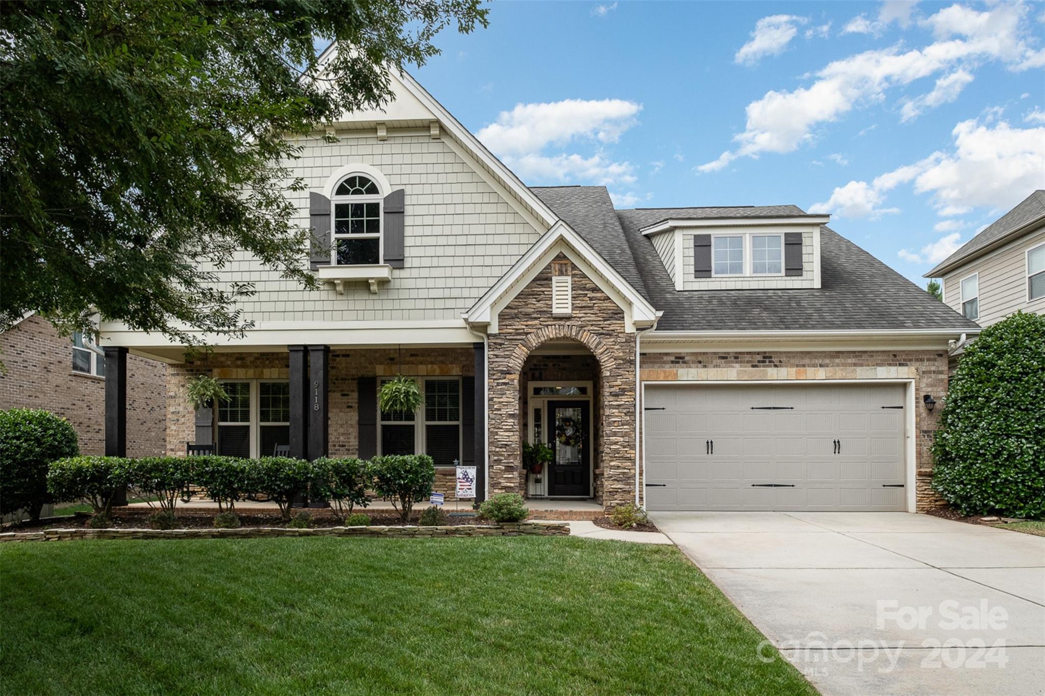 Welcome to 9118 Blue Ridge Drive, a stunning 4-bedroom, 3.5-bath home located in the desirable Fort Mill area. This home boasts hardwood floors throughout the main living areas and an inviting stone fireplace that adds warmth and charm to the open floor plan. The spacious eat-in kitchen seamlessly flows into a covered porch and a beautifully designed paver patio featuring a relaxing jacuzzi—perfect for outdoor living and entertaining. The main-level primary bedroom offers a luxurious ensuite with dual vanities, creating a private retreat. The property is beautifully landscaped, providing a serene and picturesque setting you'll love coming home to.
