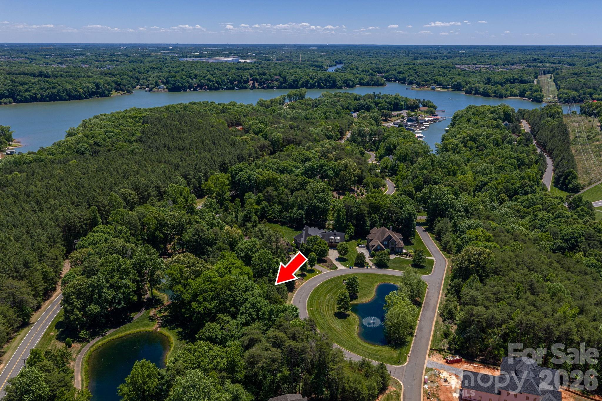 Located on the most coveted, rare, crawlspace lots in Reflection Pointe, this is THE ONE you've been waiting for!  Imagine turning down to the quiet southern tip of South Point Road, driving through the stunning gates of Reflection Pointe, and pulling up to a home designed entirely by you. While most available homesites require intense grading, 1116 Verdant Ridge Circle offers a rare, beautifully-level, 0.7-acre canvas wrapped in mature trees for built-in privacy. Situated at the scenic, southern tip of the South Point Road peninsula, called "The Point" by locals, this lot balances quiet luxury with resort-style living. Here, you're just a short walk from Lake Wylie access and neighborhood beach, covered picnic area, secure boat storage, community clubhouse, wade-in pool, tennis courts, playground, and putting green. Enjoy a serene backdrop with multiple pond views, fountains, and easy access to a walking trail from the rear corner of your lot! The rare view from the front of your lot features a dedicated park area with an additional pond and fountain!  All this is paired with a quick commute to Charlotte and minutes from downtown Belmont!