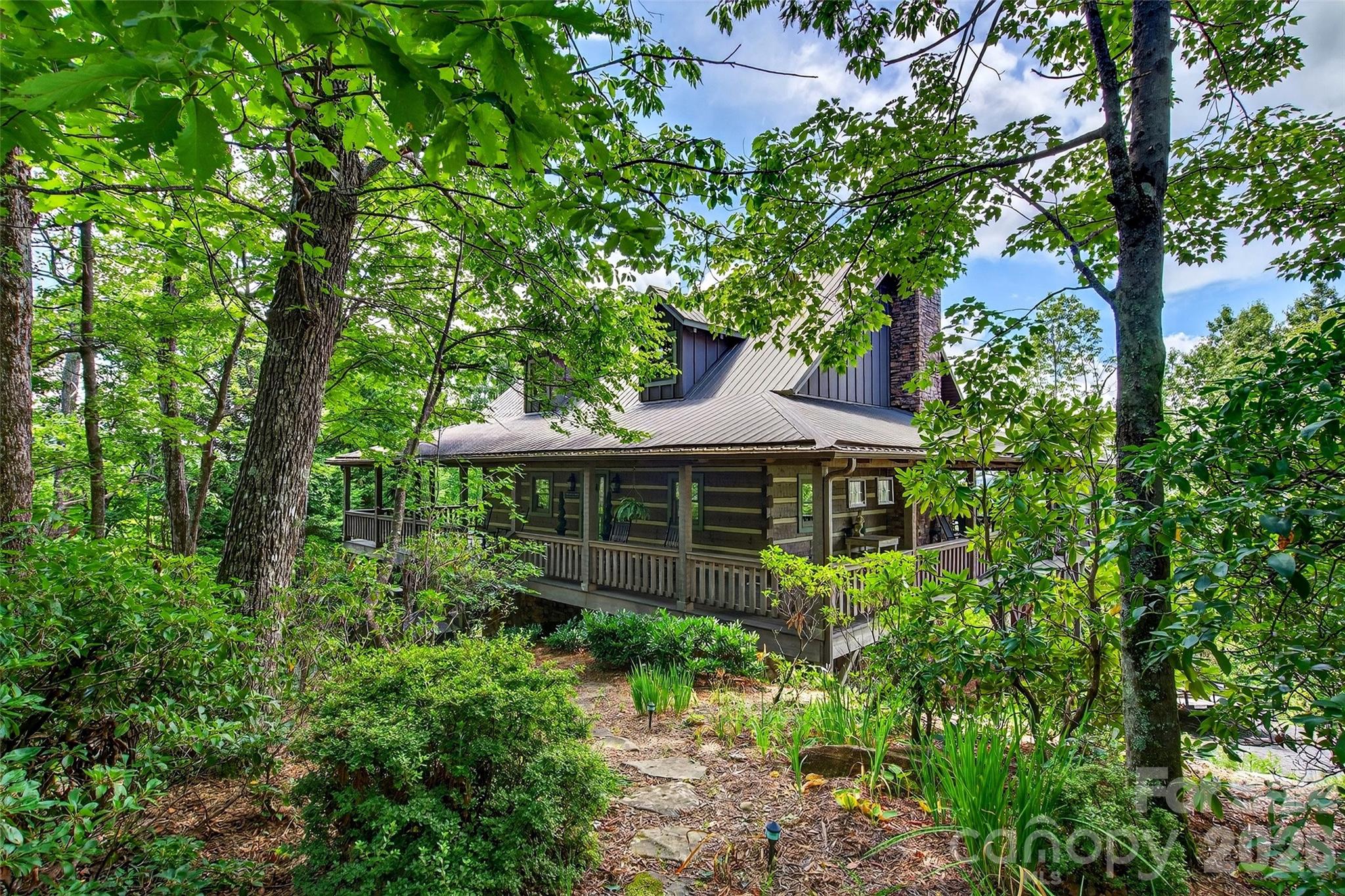 Enjoy the peace and privacy of nature in this true mountain retreat, all while being just minutes from Asheville and other popular destinations. Designed to capture the beauty of its surroundings, this home features a stunning wraparound porch, large and spacious sunroom, and screened-in porch—perfect for taking in panoramic views of Lake Lure nestled in the valley below, with mountains rising on every side. This well-maintained home showcases quality construction throughout. Please note you get an additional 1.52 acre lot making the total acreage over 4 acres. This lot can be a privacy buffer or investment lot to sell later.

Built to highlight the breathtaking scenery, the home offers convenient main-level living with layered mountain views. The light-filled kitchen features ample cabinetry, or step outside to cook on the screened-in porch while enjoying the fresh mountain air. Also on the main floor you will find the primary bedroom with an ensuite bath, a half bath with a laundry, foyer, kitchen and dining. With just opening the double doors, you can enjoy the large screened porch as well as the deck space.

Upstairs, you’ll find a loft currently used as a family room, along with a full bath and a spacious bedroom with an en suite bathroom as well as offering beautiful mountain views.

The lower level provides a warm and inviting space with an additional fireplace—perfect for entertaining or relaxing with a good book. This level also includes a large bedroom and en suite bath.

You’ll also find a garage and workshop on the lower level, offering plenty of storage and functional space.

Rustic charm blends seamlessly with modern comfort, featuring warm wood interiors, soaring ceilings, and thoughtful craftsmanship throughout, including impressive handcrafted floor-to-ceiling fireplaces. Most furnishings are negotiable, offering the option for a turn-key purchase.

Ideal as a full-time residence, second home, or investment property, short-term rentals are allowed—making this an excellent opportunity. Conveniently located just minutes from Interstate 40 and close to the area’s most sought-after destinations.

Gateway Mountain offers exceptional natural amenities, including Lake George, Waterfall Park, and Picnic Lake just down the road(please note these areas are closed to the public).

If owning a mountain home in Western North Carolina has been on your mind, this one-of-a-kind property is not to be missed. Visit www.gmpoa.org to learn about the community or schedule your own private tour today.