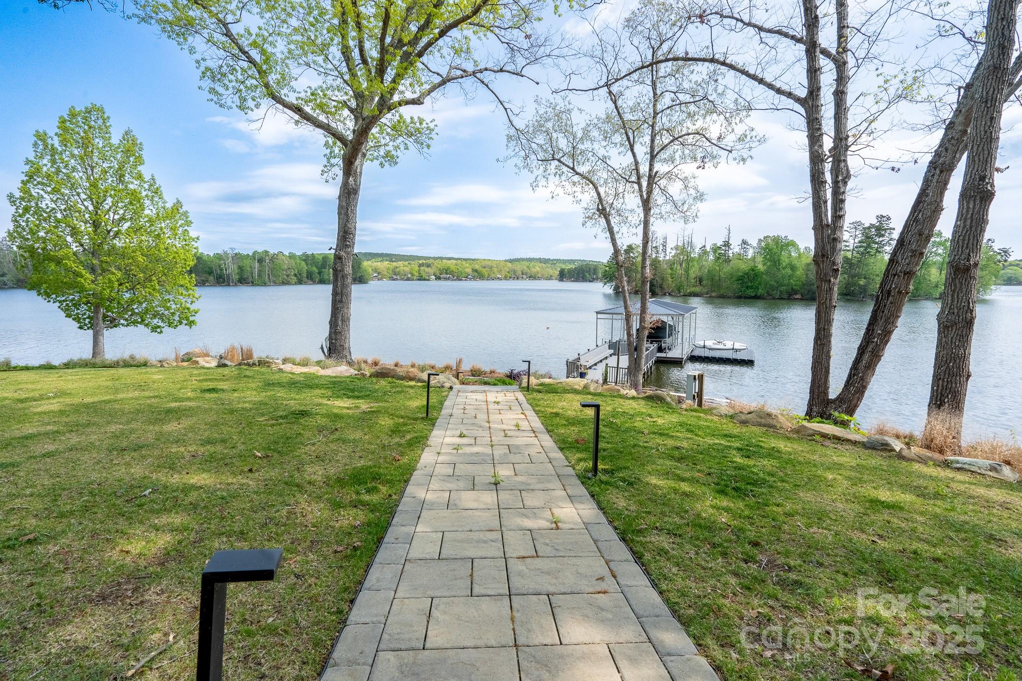 SPECTACULAR luxury lakefront home with private pier! Home being offered with designer furniture and furnishings included. Enjoy views of Badin Lake from nearly every room. Year-round, spend time on your screened porch, turf bocce ball court, or by the firepit - all a gentle walk down to the lake with fantastic main channel views. The main level provides mostly one-story living with 4 bedrooms & 3.5 baths. The Great Room, with its impressive two-story marble fireplace & abundant natural light, is a focal point of the home’s open floorplan. The upstairs living space provides plenty of room for guests with a bonus/bedroom, bedroom/rec room & guest suite. Memberships available to Old North State Club which includes championship golf, clubhouse, tennis/pickleball courts, pools, marina & idyllic walking trails are all within the Old North State Club gated community for you to enjoy. All of this & more is an hour from Charlotte, Winston-Salem & just a bit further from Raleigh.