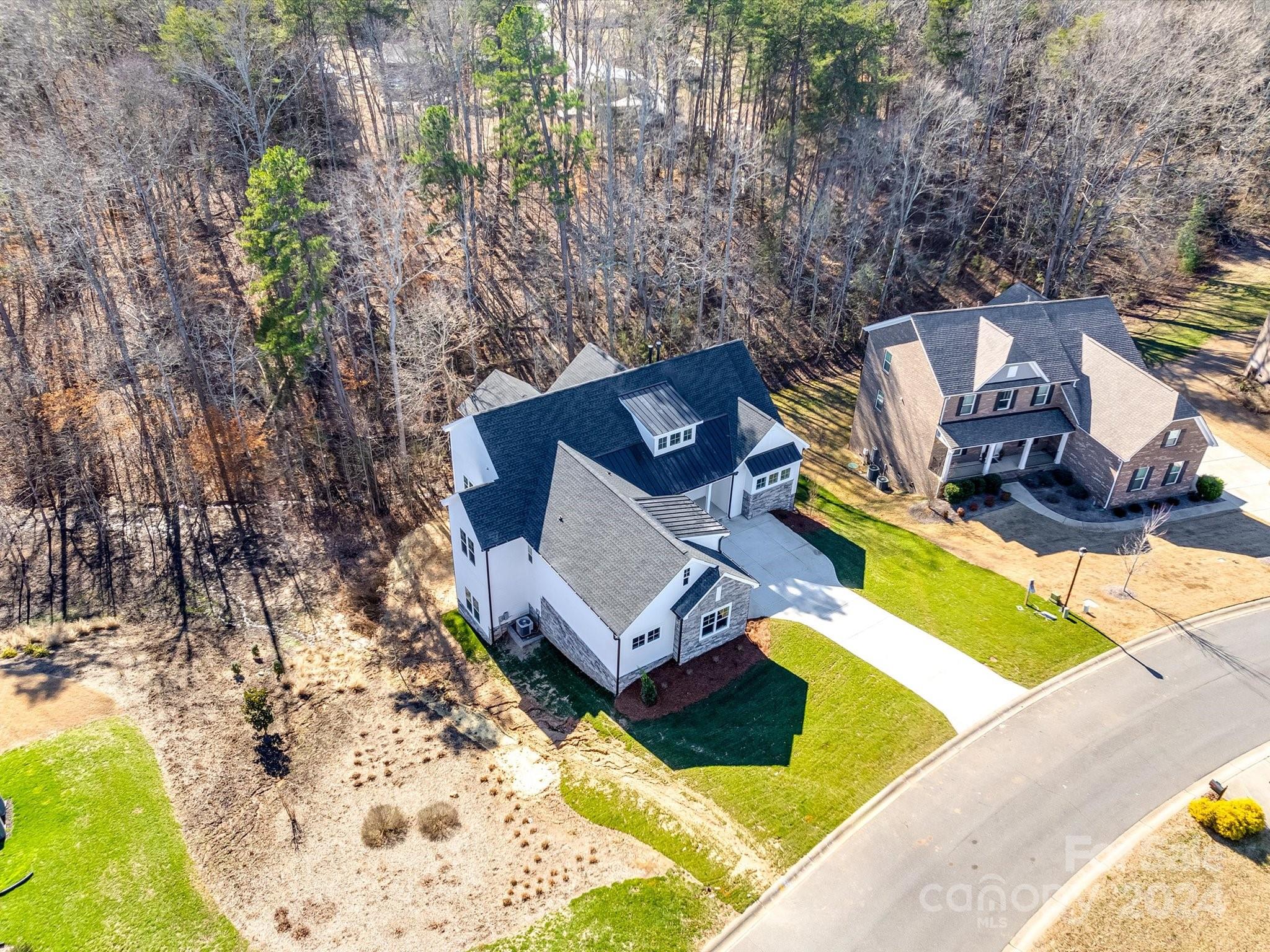 Luxurious retreat nestled on a sprawling .94-acre wooded lot. This exquisite newly constructed Ranch home with finished walk-out basement provides the perfect blend of modern elegance & serenity. The main level features an open floor plan with expansive windows allowing abundant natural lighting. Step into the gourmet kitchen where sleek quartz countertops, dovetail & soft-close cabinetry & KitchenAid appliances create an inviting space for both the novice or skilled Chef. The living area with vaulted beam ceilings & cozy fireplace is a haven for relaxation. Impressive owner's suite & luxurious bath featuring: deep free-standing tub, large shower, separate vanities & closets. Well appointed Guest Ensuite on main + 3 additional bedrooms (one is an Ensuite) on lower level. Finished basement space provides endless possibilities for both entertaining & leisure.  Savor the tranquil beauty & natural landscape from the sprawling decks & screened porch-seasonal water view. Community pool!