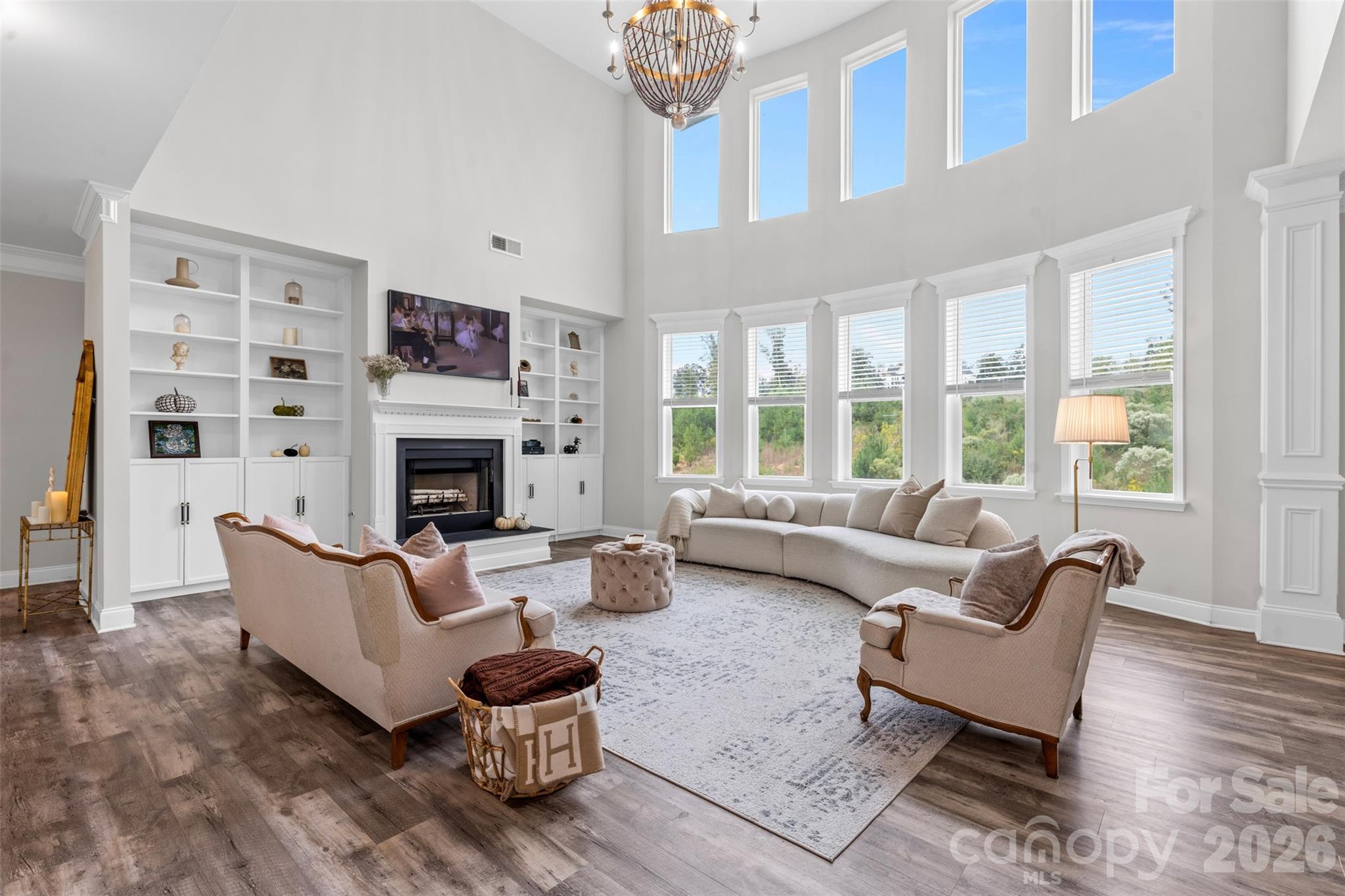 Welcome to this impeccably maintained, farmhouse-inspired retreat nestled in the heart of booming Belmont! Set on nearly an acre, this exceptional property offers a rare blend of privacy, space and timeless style — delivering a serene lifestyle without sacrificing convenience.

A charming covered front porch invites you into a light-filled, two-story foyer, where an open and thoughtfully designed floor plan unfolds. The dramatic living room, anchored by expansive windows and custom built-ins, seamlessly connects to the chef’s kitchen, featuring a generous island, crisp white cabinetry, stainless steel appliances and a spacious walk-in pantry. A formal dining room sets the stage for elevated entertaining, while a versatile main-level bedroom or bonus space, full bath and dedicated laundry room provide both flexibility and everyday functionality.

Upstairs, the primary oasis offers a true sense of retreat, complete with a spa-inspired en-suite showcasing a soaking tub, glass-enclosed shower and an oversized walk-in closet. Three additional bedrooms and two full baths ensure ample space for family and guests.

Outdoors, a covered back patio overlooks peaceful surroundings, creating the perfect backdrop for quiet mornings or effortless entertaining. A side-load garage with Tesla charger hookup adds a modern touch to this classic design.
Move-in ready and rich in character, this Belmont beauty perfectly balances comfort, sophistication and the charm of farmhouse living!
