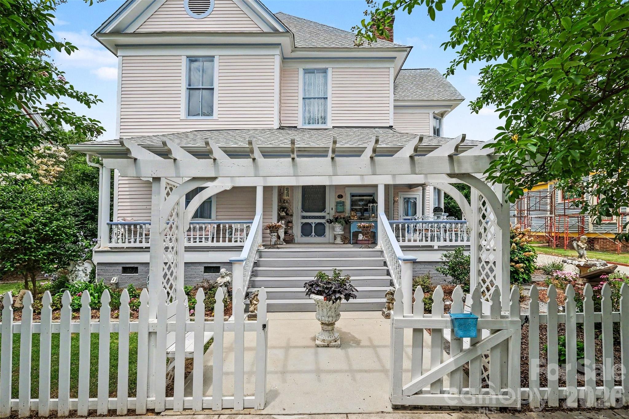 Potentially the most captivating home in Downtown Rock Hill, this one-of-a-kind residence blends historic character, designer finishes, and modern conveniences into a property that feels more like a private retreat than a home in the heart of the city. From the moment you arrive, the wraparound porch, professionally maintained grounds, and timeless architecture create an unforgettable first impression. Inside, original charm meets thoughtful updates, with soaring ceilings, rich hardwood floors, elegant fireplaces, and spaces filled with natural light and personality. The gourmet kitchen is truly the centerpiece of the home, featuring custom finishes, an oversized island, abundant workspace, and a design that is both functional and visually striking. Recent improvements including updated window glass, a tankless water heater, and a newer roof add value and peace of mind. The outdoor living spaces are equally impressive. Enjoy a private courtyard-style backyard designed for entertaining and relaxation, complete with a covered porch and beautifully maintained landscaping. A detached 2-car garage—an uncommon and highly sought-after feature in Downtown Rock Hill—provides exceptional convenience and versatility. The spacious primary suite offers a luxurious escape with a beautifully updated bath that feels inspired by a boutique hotel. Throughout the home, every room showcases a level of character and craftsmanship rarely found in today's market. Located just moments from Downtown Rock Hill's vibrant collection of restaurants, breweries, shops, historic landmarks, public art, and year-round events, this property offers the opportunity to enjoy one of the area's most desirable lifestyles. Homes with this combination of architectural presence, modern upgrades, outdoor living, garage space, and walkable downtown convenience rarely become available. A truly exceptional Downtown Rock Hill property. see feature sheet in attachments for a list of more upgrades.