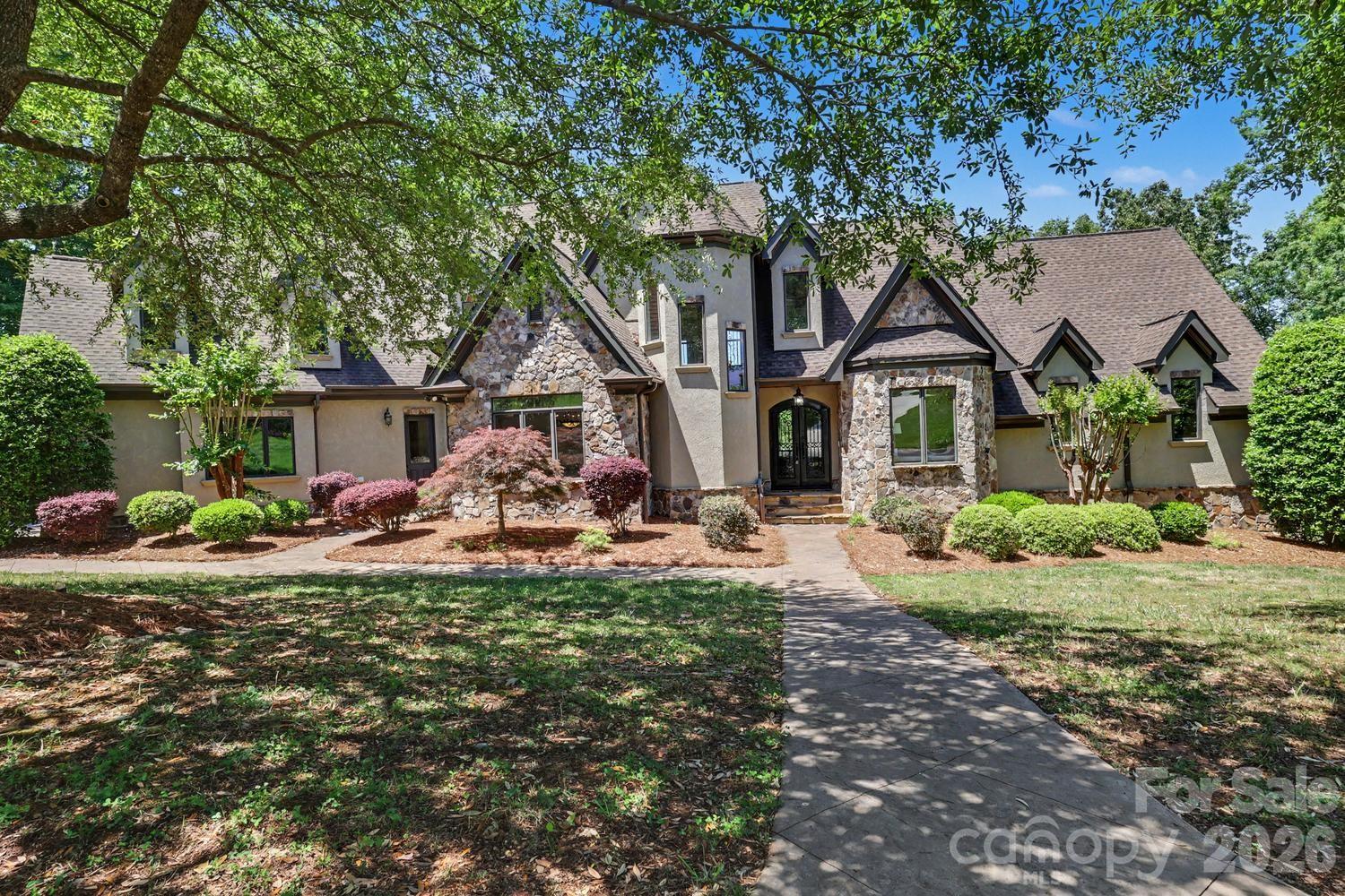Exquisite one owner home on an almost 1 acre lot with wonderful water views. Nestled in a prestigious gated community, this 2008 custom-built stone and stucco residence offers the perfect blend of elegance, comfort, and functionality. Boasting breathtaking water views, this home is designed to capture natural light and showcase serene surroundings from nearly every room. The main living areas feature high-quality finishes, thoughtful architectural details, and an open, inviting layout perfect for both entertaining and everyday living. Chef’s kitchen is thoughtfully designed for both culinary excellence and effortless entertaining. The generous layout offers ample prep spaces with center island + an eat-in dining area perfectly positioned to capture serene water views. The spacious main-level primary bedroom is a private retreat designed for comfort and style. A cozy fireplace adds warmth and ambiance, while a built-in bar elevates the space for relaxation. The suite also features an attached office/flex space, perfect for work-from-home needs, a private study, or a personal lounge area—combining functionality and luxury in one elegant setting. Upstairs Bonus Room provides a versatile living space—ideal for a home theater, recreation area, or guest suite with full bath. Enjoy ultimate convenience with dedicated laundry rooms on the first and second floors. Finished lower level has one bedroom with full bath and a family room that has french doors leading to patio. Step outside to enjoy tranquil vistas from your private outdoor spaces, where the beauty of the water and surrounding landscape create an unparalleled backdrop for relaxation. Secure, serene, and sophisticated, this home offers the ultimate in privacy and luxury within a coveted gated community.