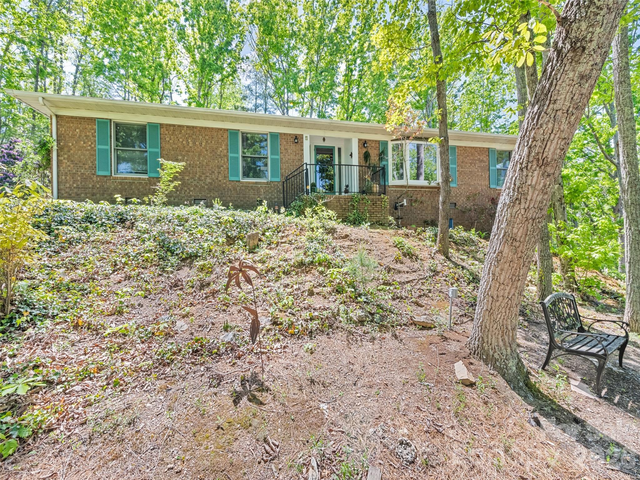 Perched above the trees with mountain views, this inviting North Asheville home offers a peaceful setting and easy one-level living. Known as “The Bird House,” the property is nestled on .89 acres in the desirable Woodfin area and features 3 bedrooms, 2 full bathrooms, and 1,955 square feet of thoughtfully designed space. Natural light fills the home through well-placed light tunnels, enhancing its warm and welcoming feel. The primary suite includes a walk-in shower, while the secondary bath features a jetted tub. A large heated atrium just off the kitchen provides a versatile space to relax, garden, or gather year-round. Outdoor living is just as appealing, with a spacious deck overlooking a fenced backyard—ideal for a small dog—and a landscape filled with a variety of established perennials. The 2-car garage offers ample storage, including a cedar walk-in closet for seasonal items. With no HOA and a 2-year-old HVAC system, this home blends comfort, character, and convenience in a serene mountain setting.