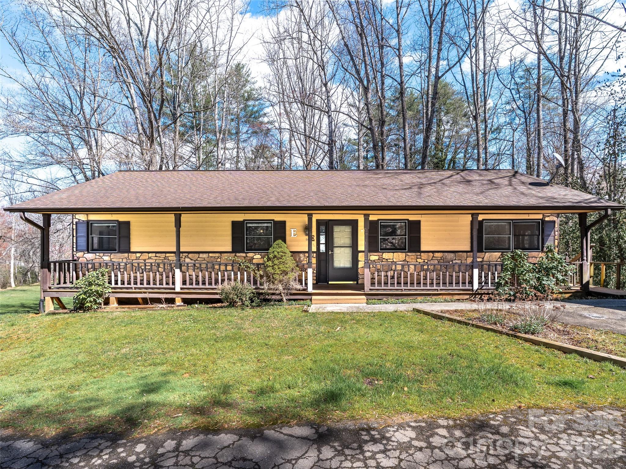 Welcome to your peaceful Etowah retreat! This rare condo is a true hidden gem. Unlike most units, it shares no common walls with neighbors, giving you the ultimate privacy of a detached home. Offering nearly double the space of recent neighborhood sales, it is priced to sell and leaves room in your budget for future cosmetic updates. Step inside an inviting living room with vaulted ceilings, exposed beams, skylights, and a stunning stone fireplace. The main level features new carpet and flows out to a screened-in porch and open deck with tranquil pond views. Downstairs, a massive, partially finished walk-out basement with a private entrance offers endless potential for a recreation or hobby room. Nature lovers will adore the close proximity to DuPont State Forest and the Ecusta Trail! This premier greenway is expanding through Etowah, offering miles of scenic paths moments from your door.