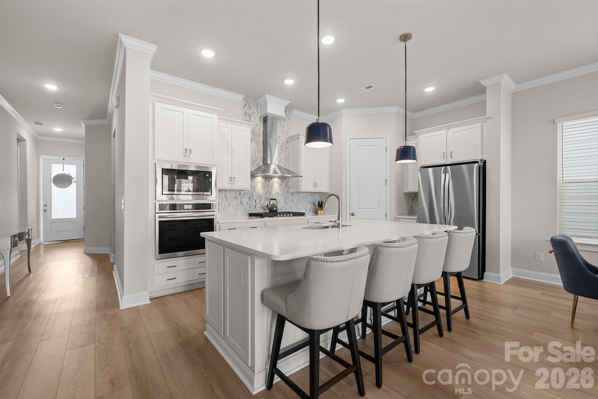 Welcome to this beautifully maintained, better-than-new home (built in 2024) in a premier 55+ active adult community! Flooded with natural sunlight and dressed in crisp, neutral tones inside and out, this 3-bedroom, 2-bathroom open floorplan is truly move-in ready. The heart of the home is a stunning gourmet kitchen boasting a sprawling island, gorgeous custom backsplash, upgraded lighting, and a premium gas range with an exhaust hood. Storage is abundant throughout, highlighted by a massive, cabinet-lined laundry room.
Step outside to a charming small garden in your backyard, which features buffered fencing and no direct rear neighbor for ultimate privacy and separation. Embrace a true lock-and-leave lifestyle with yard maintenance included in the HOA, freeing up your schedule to take advantage of the resort-style amenities just a short stroll away! Walk to the luxury pool, three pickleball courts, dog park, and walking trails. With an on-site lifestyle director curating a vibrant social calendar, this home is completely ready for its next chapter - it's more than just a house, it's a lifestyle!