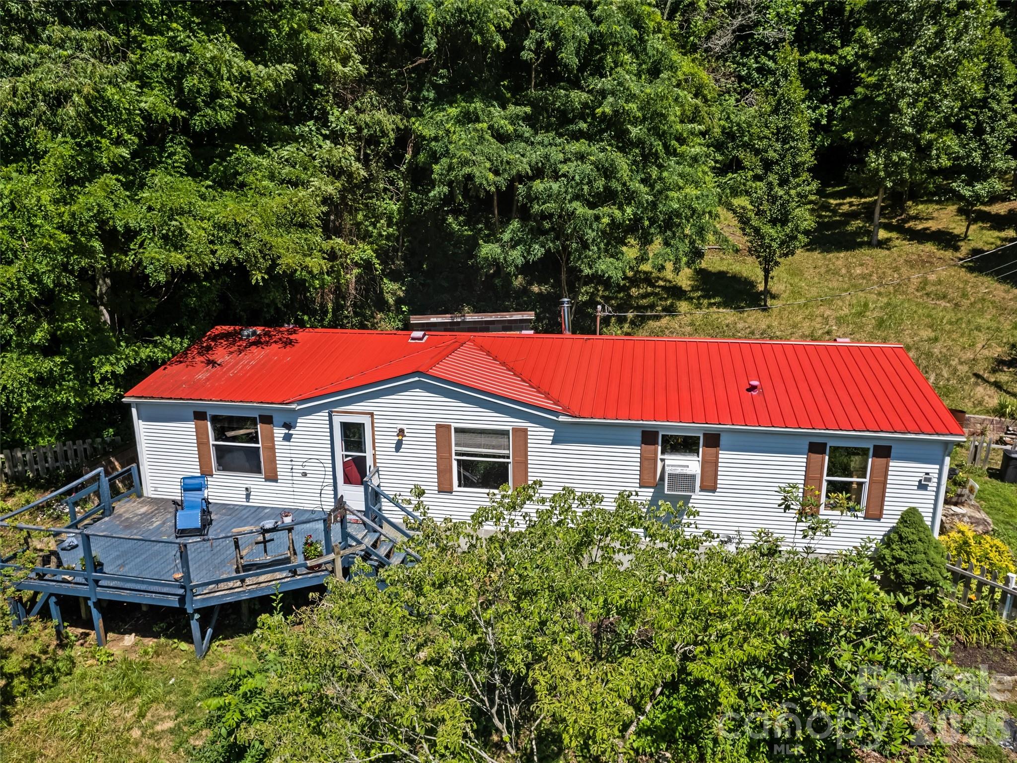 Enjoy the perfect blend of mountain charm, privacy, and convenience in this quaint home on 0.90 acres with breathtaking long-range mountain views. Offering 2 bedrooms, a bonus room, and 2 full bathrooms, this home features a desirable split bedroom floor plan, providing added privacy for the spacious primary suite with its own en-suite bathroom.
The recently updated kitchen and beautiful engineered wood flooring create a warm, inviting atmosphere, while windows showcase the stunning mountain scenery. Outside, you'll find plenty of space to relax and enjoy the peaceful setting.
A detached workshop with electricity offers endless possibilities for hobbies, storage, or a home workspace. With a little TLC the insulated cabin provides additional flexible space for a studio, office, or retreat. The gravel road was professionally redone in 2025, and the flat, easy driveway provides convenient year-round access and offer privacy.
Located less than 2 miles from the Maggie Valley Festival Grounds, you'll enjoy easy access to local festivals, dining, shopping, and outdoor recreation while still feeling tucked away in your own private mountain escape.
Whether you're looking for a full-time residence, vacation home, or investment property, this mountain retreat offers comfort, versatility, and exceptional views in one of Maggie Valley's most desirable locations.