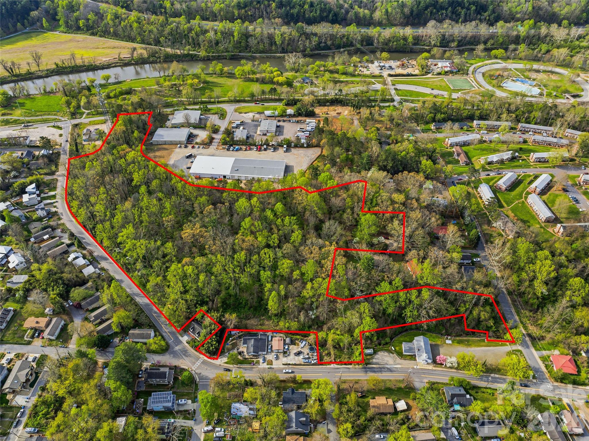 Introducing a rare 10.61-acre development opportunity in the heart of West Asheville—ideally suited for affordable and workforce housing in one of the region’s most supply-constrained and high-demand submarkets. Located within walking distance of Carrier Park, the Wilma Dykeman Greenway—offering direct access to the River Arts District— as well as essential services, transit corridors, and neighborhood amenities along Haywood Road. This site offers the connectivity and livability critical to successful affordable housing communities.
As one of the largest remaining undeveloped tracts in West Asheville, the property offers a unique opportunity to deliver much-needed housing at scale in an area where attainable options are increasingly limited. Conditionally Zoned RM-16 (CZ 08-51-010), the site is entitled under Conditional Zoning Ordinance #3682 (City of Asheville, 2008), allowing for up to 140 multifamily units. Existing entitlements and a prior site plan provide a meaningful head start, helping reduce entitlement risk and accelerate development timelines—key advantages for projects utilizing LIHTC or other funding sources.
The site’s natural features, including a small creek and generous open space, create opportunities to incorporate green space, pedestrian connectivity, and community-oriented design elements that enhance resident well-being while aligning with modern affordable housing standards.
Comprised of seven contiguous parcels, the property offers multiple access points via State Street, Short Michigan Avenue, and Amboy Road, allowing for flexible site planning and phased development. All major utilities are available at the site, enabling efficient, cost-effective construction.
With sustained demand for affordable housing, strong municipal support for attainable development, and limited land availability in West Asheville, this offering presents a compelling opportunity for developers, housing authorities, and mission-driven investors to create a high-impact community while leveraging existing entitlements and infrastructure to accelerate execution. Please contact Listing Agent for all showings. Also listed at MLS# 4370709