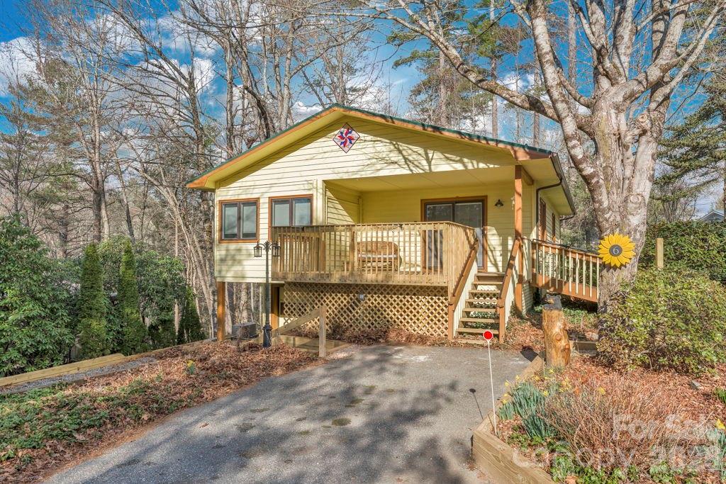 Linville Land Harbor mountain cottage across from the golf course and seasonal patio grill. Enjoy 18 round of golf in the morning and relaz on your deck in the evening after a dip in the pool. Located on a corner lot, this two level home has updated kitchen with granite countertops, stainless appliances and custom cabitnetry. Main level features two bedrooms and two updated baths as well as a sunroom off the dining area. Lower level has laundry area and full bath with room to grow. Workshop area and space to park a car and a golf cart with a door to the lower parking area. One parking spot is level with home and there is a ramp for easy entry as well as a chair lift on the interior stairs. Land Harbor offers pickleball, golf, tennis, hiking, fishing, seasonal outdoor pool, dog park and so much more. Music on Friday nights in the summer has been a big hit for this year-round resort community in the cool NC mountains.