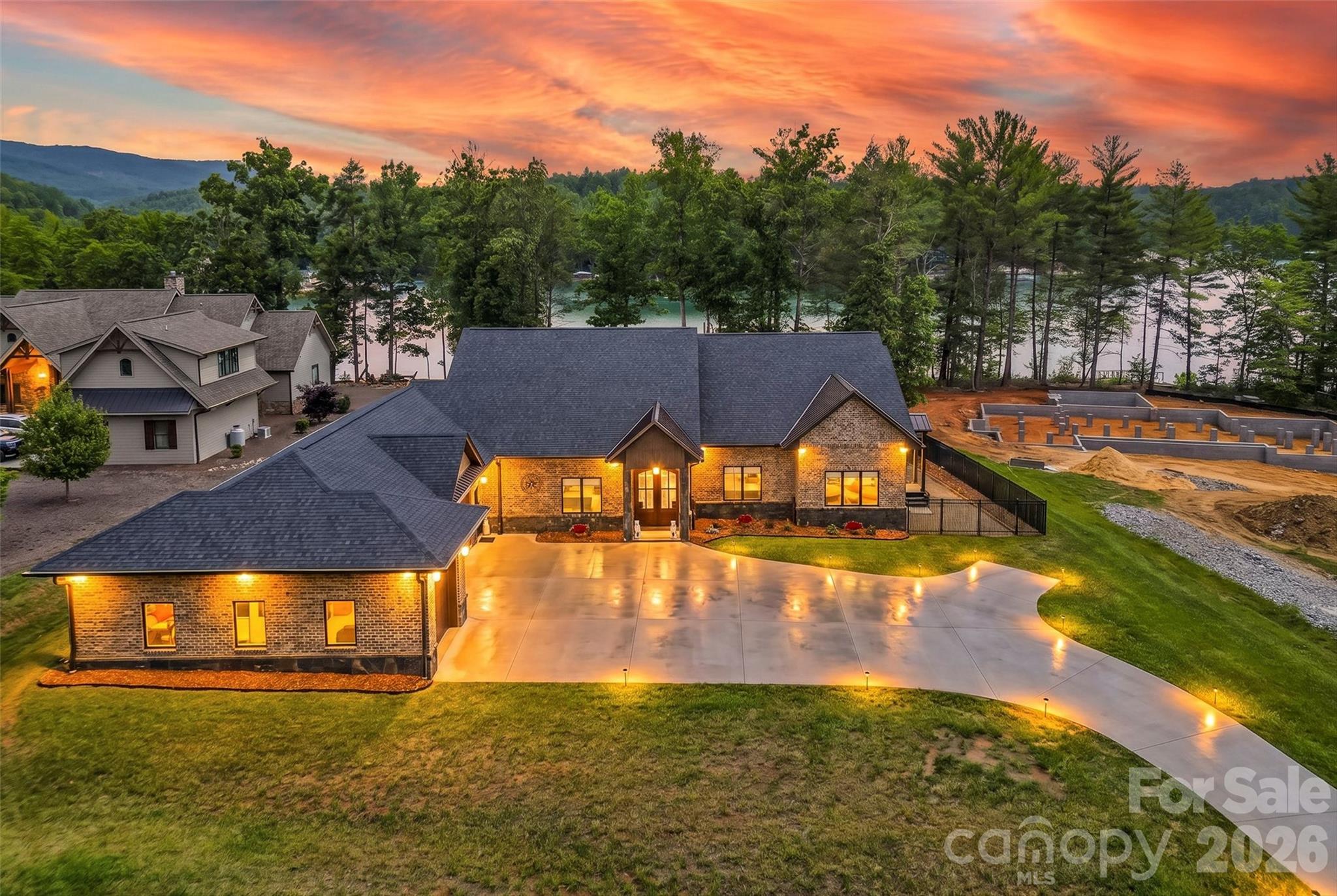 Experience ultimate luxury in this custom-built ranch home located within the gated community of The Peninsula at Lake James. From the moment you enter through the double French doors, you are greeted by breathtaking, expansive lake views that frame the home from nearly every window. Situated on a rare, nearly one-acre level waterfront lot, this property offers unparalleled access and comfort.

The thoughtful split-bedroom floor plan ensures privacy, featuring two expansive primary suites on opposite sides of the home, each boasting luxurious ensuite bathrooms complete with soaker tubs and one has a steam shower. A third bedroom offers generous space with adjacent full bathroom access. The heart of the home is the welcoming great room, anchored by a gourmet kitchen featuring a massive island and an airy dining area perfect for entertaining. Beyond the main living areas, the home offers several versatile bonus spaces ideal for a home office, gym, or potential additional bedrooms.

Outdoor living is equally impressive with a fully fenced backyard featuring durable aluminum fencing and convenient double-gate access on all sides. A covered deck and patio space allows for grilling and social time. Enjoy easy access to the community pool or relax in your private, conveying jacuzzi/hot tub. For the car or boating enthusiast, the massive 1,000+ sq. ft. tandem garage provides ample space for four vehicles or safe winter boat storage. Additional peace of mind is provided by the included backup whole house generator. This remarkable waterfront home truly offers it all.

Key Property Features:
*   Waterfront Living: Rare, level, nearly one-acre lot with expansive views from every room.
*   Primary Suites: Two private primary bedrooms with luxury ensuite bathrooms (soaker tubs and steam shower).
*   Gourmet Kitchen: Large island with open-concept dining and living areas.
*   Versatile Spaces: Multiple bonus rooms for home office, exercise studio, or extra bedrooms.
*   Garage & Storage: 1,000+ sq. ft. tandem garage with capacity for four cars or boat storage.
*   Outdoor Amenities: Fully fenced yard, private hot tub, and community pool access.
*   Added Value: Whole-home generator conveys with the property.
*   Prime Location: Situated in the well known, gated community of the Peninsula at Lake James.