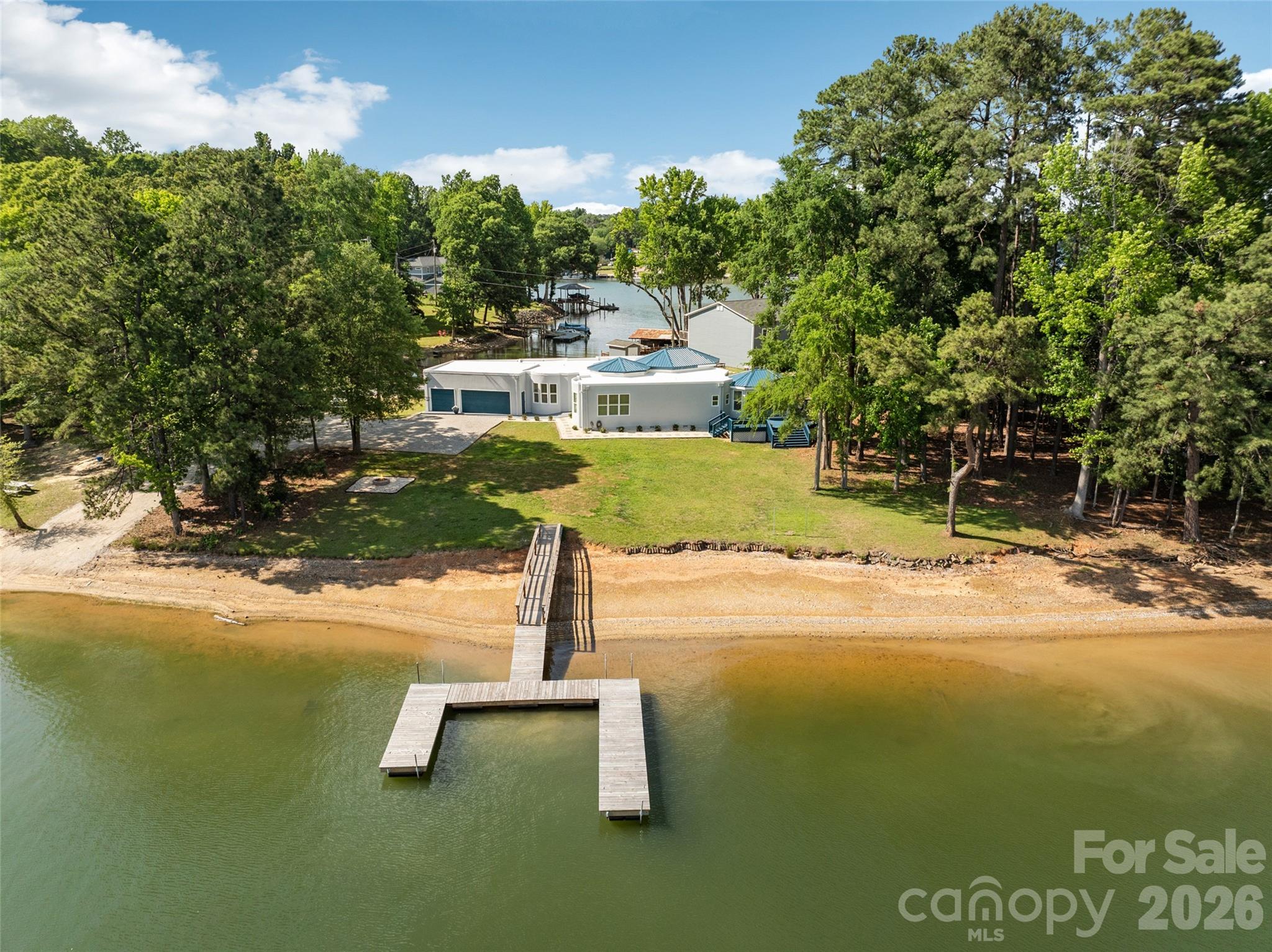 There's custom. And then there's 3911 Sandy Point Drive.

Set along approximately 263 feet of shoreline on beautiful Lake Wylie, this one-of-a-kind contemporary waterfront residence offers something increasingly difficult to find: a truly original home designed around the water, the views, and the lifestyle.

From the moment you step inside, soaring 14-foot ceilings and walls of glass draw your attention to the lake beyond. Natural light pours through the open-concept living spaces, creating an atmosphere that feels both dramatic and relaxed. Every detail was thoughtfully designed to maximize views and connect indoor and outdoor living.

The chef-inspired kitchen serves as the heart of the home, featuring butcher block countertops, stainless appliances, generous workspace, and effortless flow into the gathering areas, perfect for casual evenings or hosting unforgettable waterfront celebrations.

With four spacious bedrooms and three full baths, including a luxurious primary suite designed as a private retreat, this single-story floor plan delivers convenience without compromise. No stairs to navigate. No wasted space. Just seamless everyday living.

Outside is where this property becomes extraordinary.

A floating dock invites early-morning fishing trips, afternoon paddleboard adventures, sunset cruises, and spontaneous lake days. Bring the boat. Bring the jet skis. Bring the friends. The shoreline becomes your backyard playground, while panoramic water views provide a daily reminder of why people dream about lake living.

Life here extends far beyond the property itself. Residents enjoy everything that makes the Lake Wylie area so sought after, water recreation year-round, local waterfront dining, marinas, golf courses, parks, and convenient access to both York and the greater Charlotte metropolitan area. Nearby destinations such as Papa Doc's Shore Club, The Garrison, and the vibrant lakefront communities surrounding Lake Wylie create endless opportunities for dining, entertainment, and recreation.

York County offers the charm of a small-town atmosphere while remaining close to major employment centers, shopping, healthcare, and Charlotte Douglas International Airport. The property is also served by schools assigned to the highly regarded Clover School District attendance area.

The reality is simple: homes like this rarely become available. A custom contemporary design. Single-story living. Direct waterfront access. Expansive shoreline. Acre-sized lot. Unforgettable views.

You can build a house.

You can renovate a house.

But you cannot recreate this setting.

3911 Sandy Point Drive isn't simply a place to live; it's the opportunity to own a piece of Lake Wylie that very few people will ever experience. Boat ramp
Is not part of this property