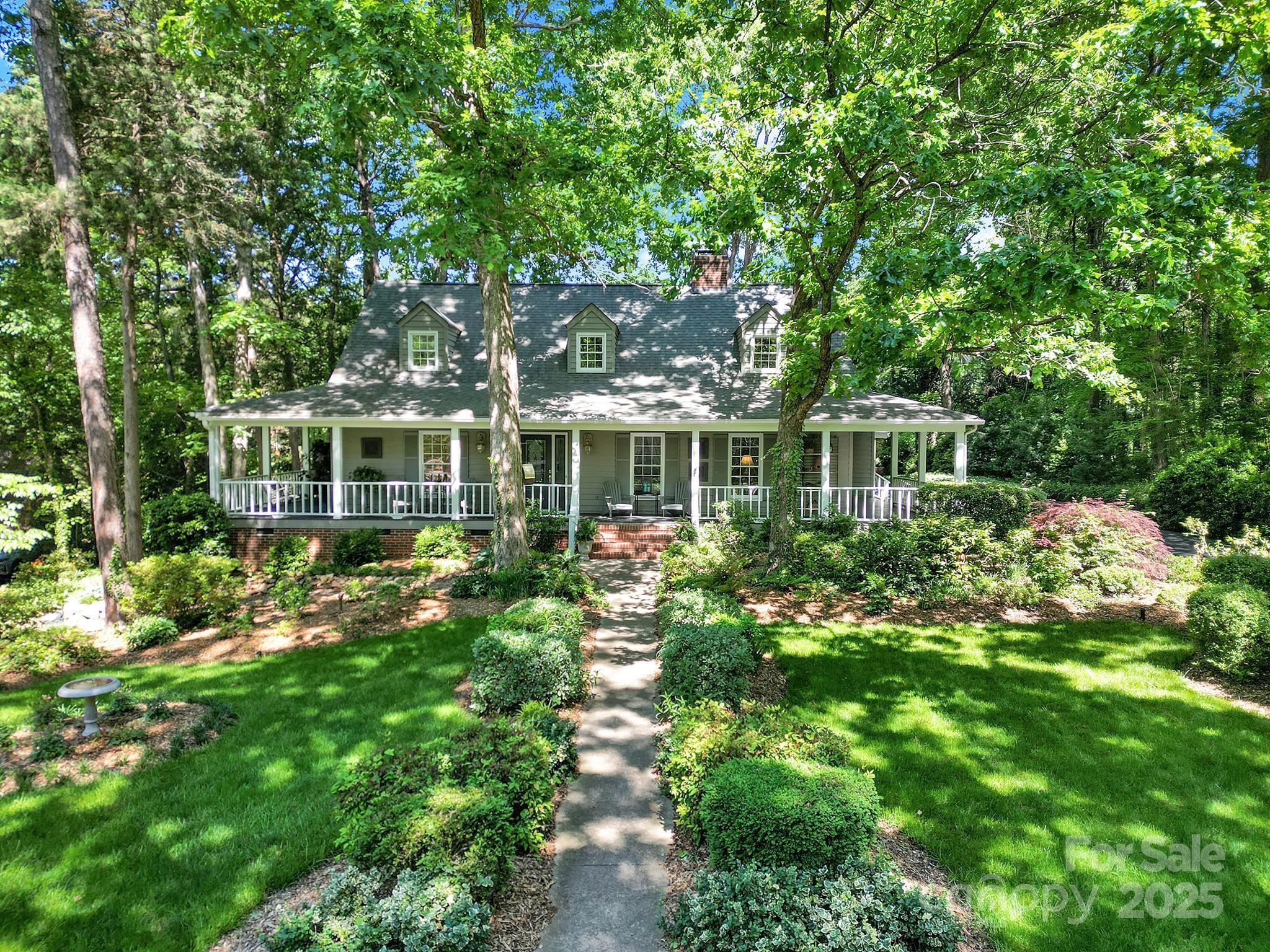 Located in the gated golf community of River Hills on Lake Wylie, this home with an incredible wrap-around porch sits on a quiet dead-end street, backing to green space near the shoreline and community garden. Inside, an impressive double-sided fireplace is between the dining room and living room and the family room with vaulted ceilings, skylights, bar, and a fireplace is connected to the gourmet kitchen with bay window seating and the breakfast nook. The primary suite is located on the main level, and a side-load garage adds to the home’s functionality. This property combines a peaceful setting with access to extensive community amenities including a marina, an 18-hole golf course, clubhouse with dining, two pools—including one with a Tiki bar—tennis courts, a dog park, playgrounds, and miles of walking trails. The neighborhood also features a lakeside park with a sandy beach and gazebo, as well as 24/7 security and gated entry.