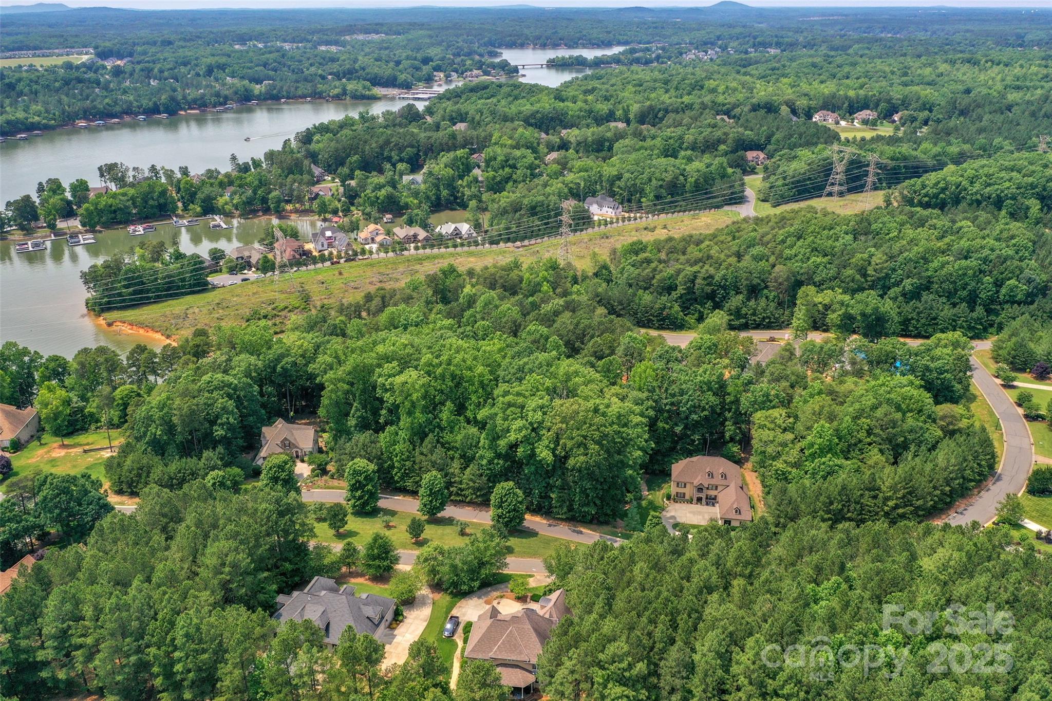 Secure a premium custom home site in the prestigious Reflection Pointe gated community, located in charming Belmont, North Carolina. This unique lot is perfectly suited for a walkout basement construction and features seasonal water views of Lake Wylie from the rear of the property. Positioned deep within the neighborhood for maximum privacy, the lot borders protected community green space, ensuring a tranquil, natural backdrop for your future residence. Reflection Pointe is a true custom-built destination with established architectural standards, requiring a minimum of 2,000 HLA for single-story homes and 2,400 HLA for two-story homes. Residents enjoy a resort-style lifestyle with world-class amenities, including a clubhouse, swimming pool, putting green, lighted tennis courts, and paved walking trails. The community also caters to outdoor enthusiasts with a waterfront pavilion, private beach, marina area, boat storage, and a soccer field. Located just outside of downtown Belmont, which offers restaurants, breweries, retail, and more.  Commuting to Uptown Charlotte is just 30 minutes, and traveling to Charlotte Douglas International Airport is 20 minutes, whether for business or pleasure.