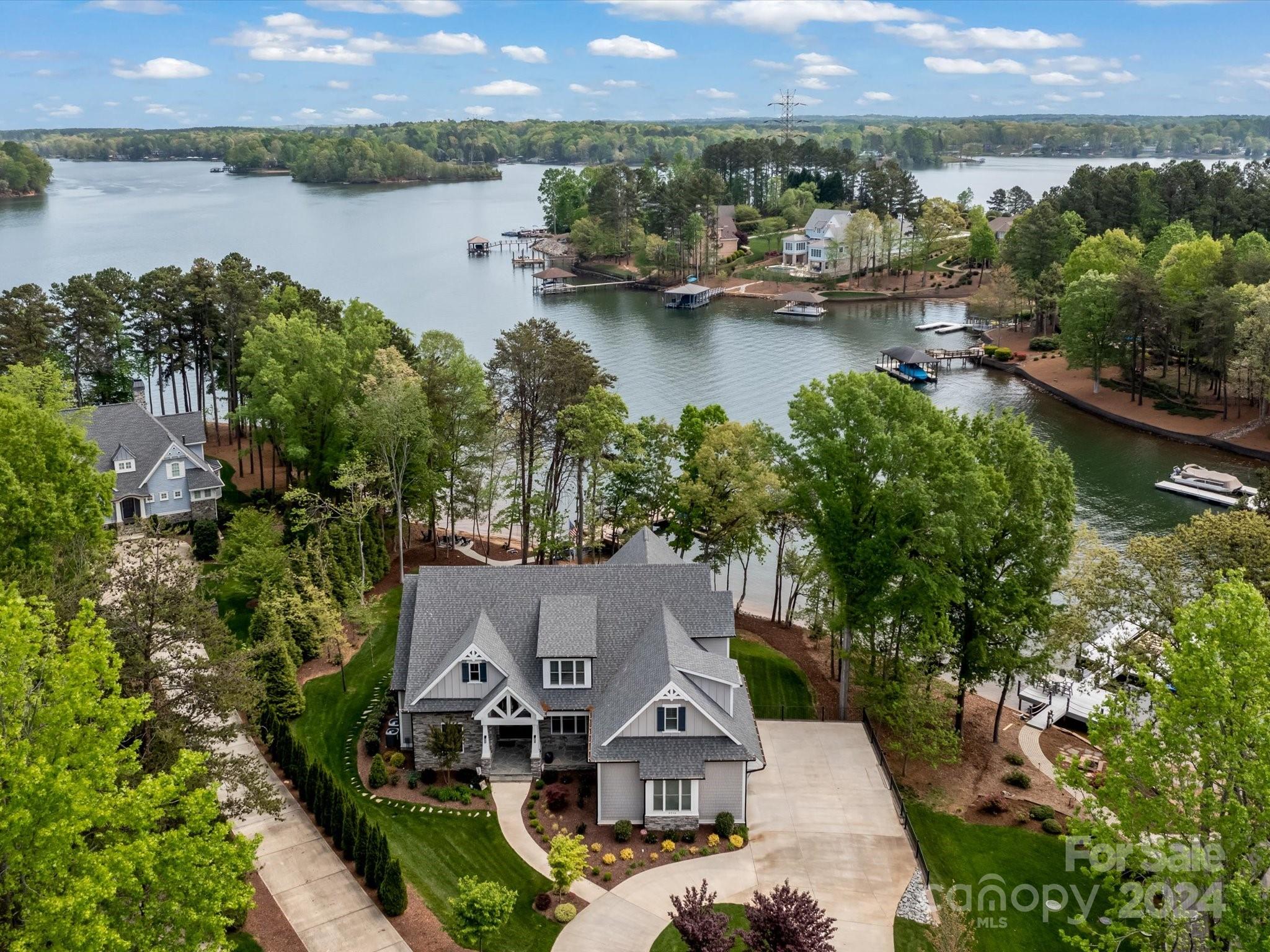 Exquisitely crafted waterfront residence nestled in the sought-after Northview Harbour! This masterpiece by G.P. Kon Custom Homes boasts every luxury imaginable: an elevator, main-level owner's and guest suites, three additional bedrooms upstairs each with their own full bath and large closets, a three-car garage with side entry, a floating dock and pier, an airy open floor plan. Relax with the outdoor fireplace on the screened porch, overlooking your lot boasting 145 feet of shoreline with breathtaking views. Enjoy custom closets, soft-close cabinets, a gas cooktop, double oven, and a lake-fed irrigation system. Plus, it's pre-wired for surround sound and a security system. 

The luxurious lake level features a quiet secluded office, workout space, large inviting bar and entertainment area, as well as direct access to the lake.