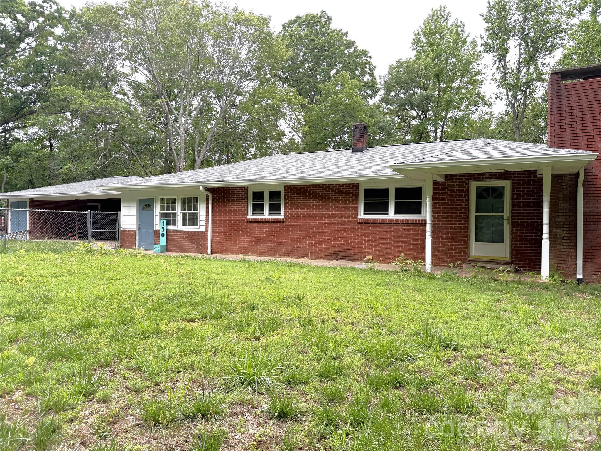 This classic 3 bedroom, 2 bathroom brick ranch style home provides almost 4 inviting acres, that offer the feeling of privacy and peacefulness, while at the same time, being within half a mile to quaint, historic downtown Tryon, and 20 minutes to the Tryon International Equestrian Center, allowing you to enjoy surrounding amenities at your whim. Head back home to a lovely, refreshing inground pool that was completely renovated so that you can "jump right in"! Downstairs provides access to the backyard pool, and includes a large multi-purpose room, complete with a bedroom and the second bathroom which has been beautifully updated. On the main level, newly refinished original hardwood floors throughout add charm, along with the vintage and rustic interior. 2 bedrooms on the main floor share a large bathroom that includes a jetted tub. The roof, gutters, and HVAC system are brand new, and the electrical system has been updated, offering peace of mind as you settle in. Homeowners and pets alike will enjoy the large, fully fenced, yard. A large carport allows room for entertaining, storage, and hobbies. If it gets a bit chilly, head into the attached, enclosed porch to enjoy the sun and stave off the wind. Come to charming Tryon and see a true hidden gem in North Carolina.