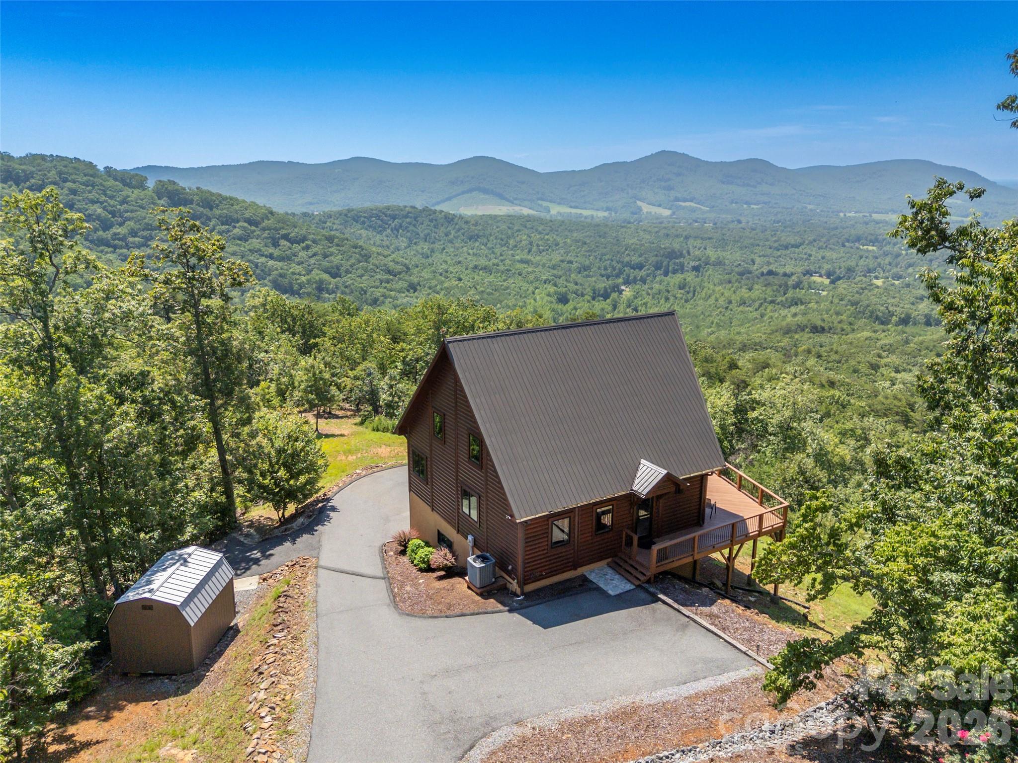 Welcome to your mountain escape. Situated on more than 11 private acres in the gated community of Yellowtop Mountain Estates, this beautifully crafted timber block 3-bedroom, 3-bath cabin offers the kind of long-range mountain views that are rarely found. Combining the warmth and character of log-style construction with the strength and energy efficiency of timber block design, the home is thoughtfully built for both beauty and lasting quality. Soaring vaulted ceilings and expansive windows fill the interior with natural light while perfectly framing the surrounding landscape. The 1.5-story floor plan with a fully finished basement offers generous living space for family and guests, while the spacious deck invites you to unwind and take in the ever-changing mountain scenery. A one-car garage, detached outbuilding, and buried 1,000-gallon propane tank add everyday convenience to this exceptional property. Yellowtop Mountain Estates allows short-term rentals, making this an excellent opportunity for those seeking a full-time residence, private mountain getaway, or income-producing investment. Whether you're looking for a primary residence, second home, or vacation rental, this mountain retreat delivers privacy, comfort, and unforgettable views in one of Rutherford County's most desirable gated communities.