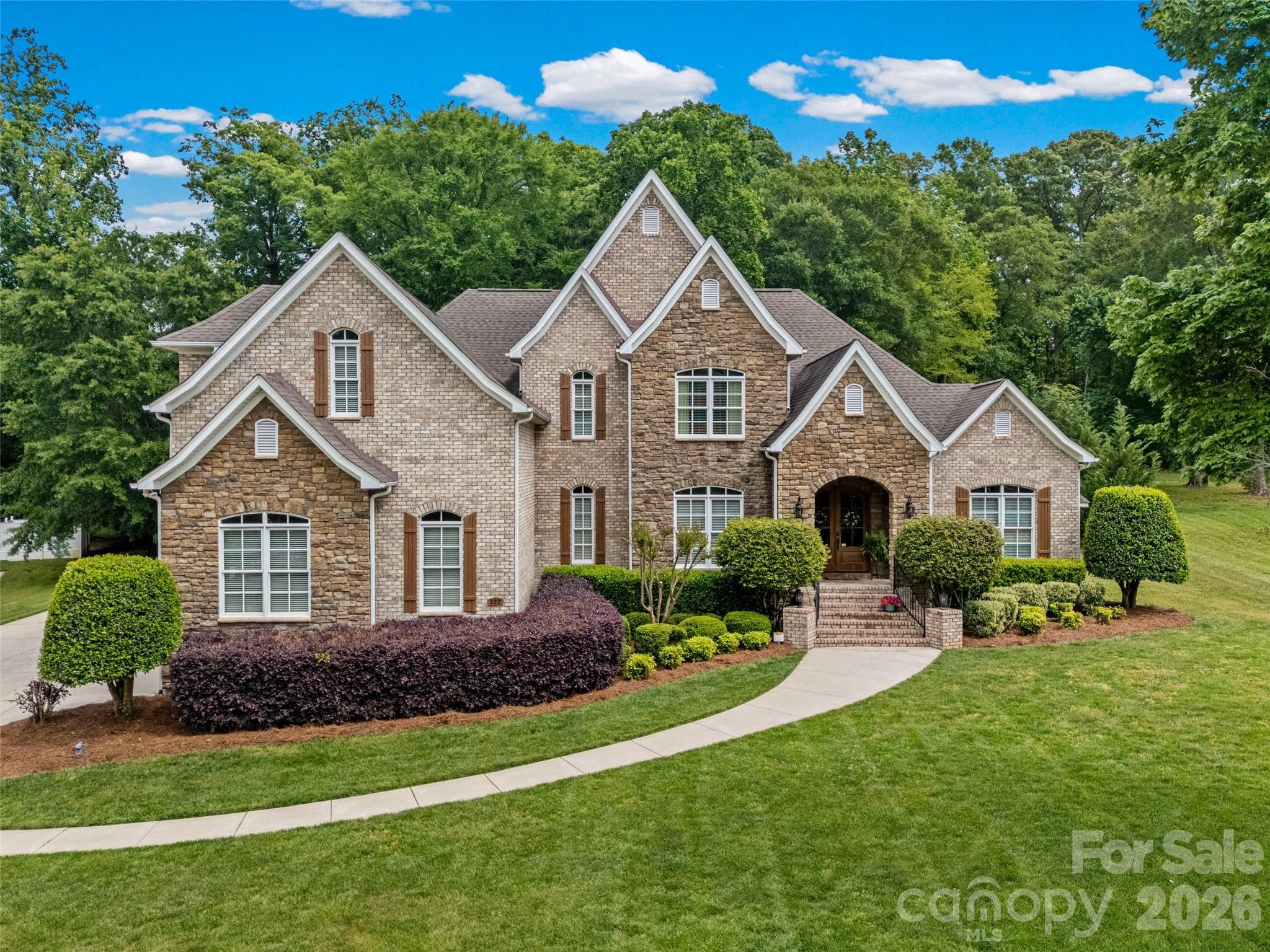 Tucked in a prime location between York and downtown Rock Hill, 222 Lord Dunluce Street offers the perfect blend of space, comfort, and convenience—plus the added bonus of NO city taxes.

 

Built in 2009 and meticulously maintained, this home sits on a stunning 1-acre lot with a sprawling, well maintained lawn and irrigation system and mature trees that provide shade, privacy, and a peaceful setting. The outdoor living is truly exceptional, featuring a covered patio with a built-in grill, refrigerator, and gas log fireplace, an adjacent sun deck, and plenty of room to relax—whether it’s enjoying an afternoon nap in a hammock or entertaining guests year-round.

 

A set of wide brick stairs with black metal railing leads to the welcoming front porch with double mahogany doors leading into a grand 2-story foyer with a winding staircase. Inside, you’ll find hardwood floors and extensive crown moldings throughout the main living areas and primary suite, adding warmth and elegance.

 

The primary suite on the main level is a true retreat—spacious enough for a seating area and thoughtfully updated with a beautifully remodeled bathroom featuring dual vanities, expansive counter space, a frameless glass shower, soaking tub, and a custom walk-in closet with built-ins for optimal organization.

 

The main floor also includes a private office with French doors, coffered ceiling, and its own gas log fireplace, a formal dining room, a large laundry room with sink, a built-in desk, and a functional, open layout perfect for everyday living.

 
The kitchen offers extensive custom cherry cabinetry, granite countertops, a walk-in pantry, a connected dining area, and flows seamlessly into the impressive 2-story living room with stone fireplace. 
Upstairs, you’ll find three generously sized bedrooms, including a Jack-and-Jill bathroom shared by two rooms and a third bedroom with a large ensuite bathroom with separate shower and tub. The oversized bonus room provides incredible flexibility—ideal for a media room, playroom, gym, or additional living space.
Additional highlights include an oversized 3-car garage, timeless architectural details throughout, and the freedom of NO HOA.
This home checks all the boxes—space, character, outdoor living, and location. A rare find in the Rock Hill area!