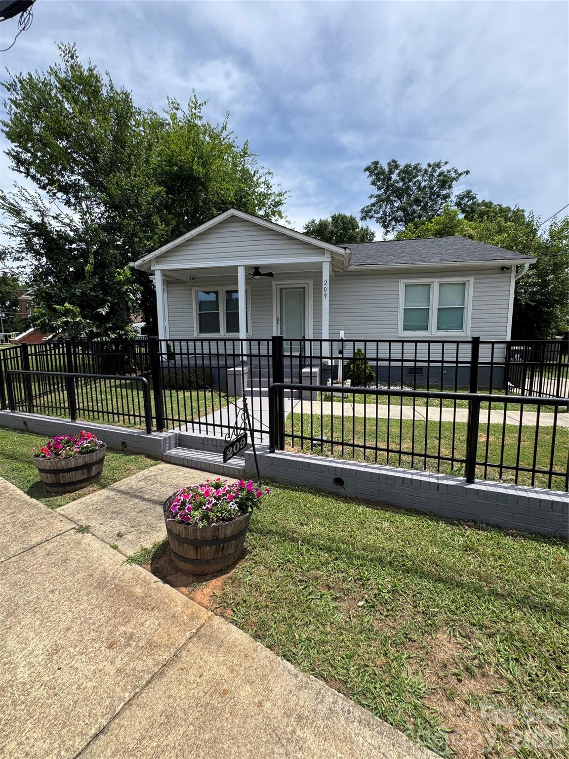 Welcome home to this charming cottage-style 2BR/1BA home in Rock Hill full of warmth and thoughtful updates. Home has inviting covered front porch and attractive iron fencing with 3 gates for added curb appeal and functionality. 

Step inside to an open-concept layout where the living room flows seamlessly into the dining area and spacious kitchen.The beautiful kitchen offers stainless steel appliances (including refrigerator, washer, and dryer),quartz countertops, and plenty of space for cooking and gathering. Luxury vinyl flooring runs throughout the home, complemented by recessed lighting and updated finishes. The bathroom features a stunning floor-to-ceiling tiled shower. 
Front and back full-glass doors with built-in blinds and storm doors invite in natural light.
Step outside to a spacious backyard retreat with a reinforced privacy fence, a covered wood and metal pergola with fan anchored to concrete, artificial turf for easy enjoyment, and a permitted storage shed.

A cozy place to call home with inviting indoor and outdoor spaces.