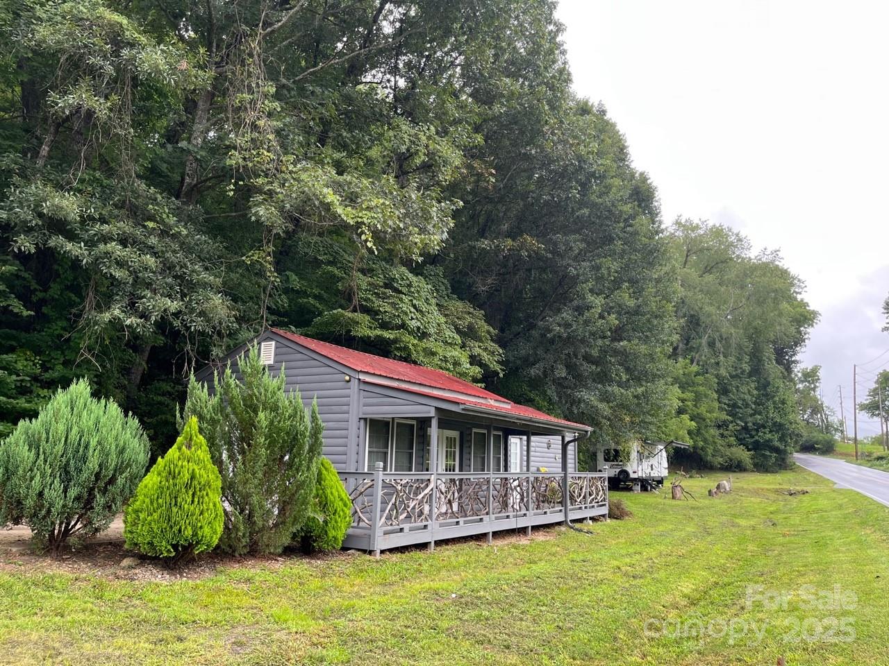 Open use Zoning. No Deed restrictions. Short term rentals allowed. Studio/home, commercial, retail, residential, multi-family, r/v park, medical, manufacturing, auto service and sales lot ETC. allowed! Circular road across the top of the property for additional residential or commercial buildings with beautiful 180 degree south views to the mountains with million+ dollar homes across valley. 575 feet of road frontage on Cane Creek Road with multiple entrances and exits. Great site visibility for signage. Previously leased for stain glass studio, medical center/physical therapy, residential studio home, warehouse, auto body, auto sale lot and r/v sites.  Currently rented month to month for $1500 (building) and $600 (camper lot). Owner/Broker
