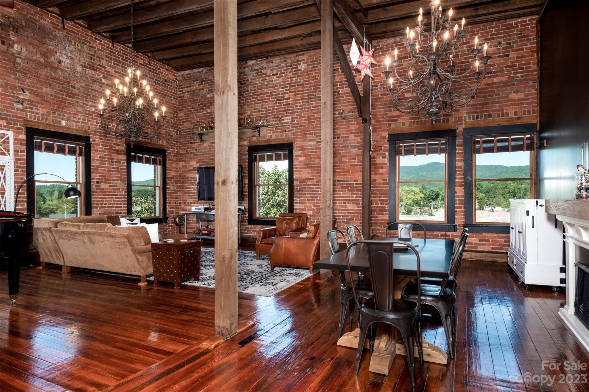 This loft is quite a unique property in the heart of downtown Brevard with charm galore! Built in the 1890s, it was once a Gentleman's Club with a balcony overlooking a downstairs theatre. The loft is the only residential unit in the historic Carrier Building. The previous and present owners have diligently preserved the character of downtown Brevard during the Victorian era with the original iron chandeliers, soaring 16 ft. ceilings, brick walls, original wooden floors, and wooden beams/ceilings. The updated kitchen houses a canopy pub bar and baby grand piano to combine the old and the new. While maintaining the historical charm, the loft is now a spacious, updated, top-floor condo with large windows overlooking the downtown area with a beautiful mountain view reminding occupants of its close proximity to Pisgah National Forest and the Blue Ridge Parkway. The loft is fully furnished and is move-in ready. There is no annual HOA fee- occupants share minimal building expenses.