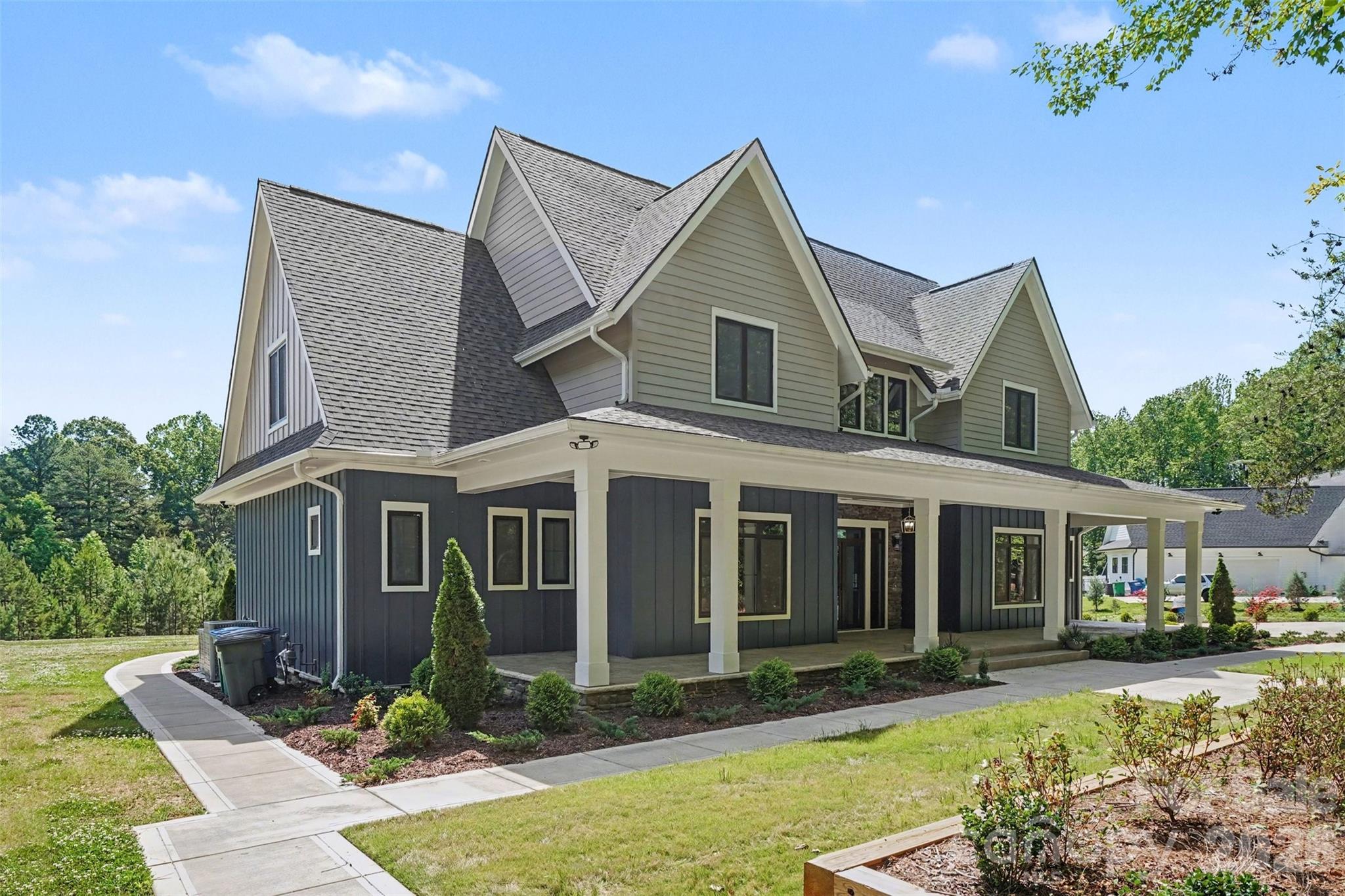 Set behind gated entry on a private two-acre parcel inside the I-485 loop, this custom farmhouse delivers rare privacy without sacrificing proximity. The setting is framed by mature trees and tranquil pond views, creating a peaceful backdrop for everyday living and entertaining. A striking modern exterior is accented by imported European windows and doors, showcasing refined architectural craftsmanship throughout.

Inside, wide-plank engineered white oak floors and designer-selected lighting establish a clean, elevated aesthetic. The main level is anchored by a spacious primary retreat with direct patio access, a customizable walk-in closet, and a spa-inspired bath featuring a seamless zero-entry shower and deep soaking tub. The kitchen commands attention with quartz surfaces, Z-Line appliances, an expansive pantry, and a walk-through scullery equipped for serious hosting, including an additional oven, dishwasher, and prep sink.

Purpose-built spaces enhance daily function, including a dedicated workstation, an oversized laundry and drop zone with convenient driveway access, and a secondary full bath on the main floor. The three-car garage includes a drive-through third bay and is complemented by an additional drop zone off the interior entry. Outdoor living continues on the covered rear patio with fireplace, overlooking a level backyard ideal for gatherings or future enhancements.

The upper level offers three generously sized bedrooms—one with a private bath—along with multiple flex and entertainment areas complete with a kitchenette, providing space to unwind, host, or adapt to changing needs with ease.

Photos virtually staged.