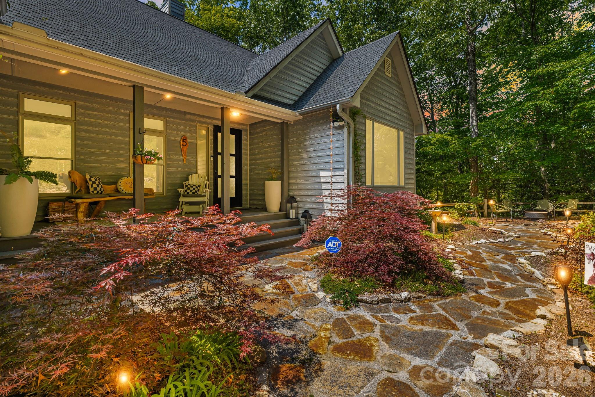Boasting spectacular long-range, year-round mountain views from the dual covered decks, this Modern Mountain masterpiece offers the pinnacle of Blue Ridge living on 1.66 private acres. Sold fully furnished with high-end furniture, lighting, and artwork, this residence is a sophisticated, turn-key sanctuary—perfect as a primary residence, premium second home, or multigenerational living. The main level is defined by a breathtaking open-plan living room featuring soaring cathedral ceilings and a majestic floor-to-ceiling stone fireplace that serves as the home's primary focal point. For the culinary enthusiast, the gourmet kitchen boasts custom cabinetry and premium high-end appliances that flow seamlessly into the formal dining area. Uniquely designed for flexibility, the lower level features a separate entrance and second living quarters, including a massive recreation room and a second primary suite. The thoughtful layout also includes a dedicated home office, fully finished garage, and an elevator for effortless access across all levels. Outdoor living is equally impressive, as the expansive decks provide the perfect vantage point in any season. The professionally landscaped grounds further enhance the retreat feel with a custom stone sofa, a welcoming front porch, and a dedicated firepit area designed for crisp Carolina evenings. While providing a profound sense of seclusion, this home remains exceptionally convenient—located less than 20 minutes from the vibrant culture of Downtown Asheville and within 15 minutes of the premier shopping in South Asheville and the Asheville Regional Airport. Complete with a whole-house generator for uninterrupted peace of mind, this property represents a rare opportunity to own a fully realized luxury lifestyle in one of the region's most sought-after locations.