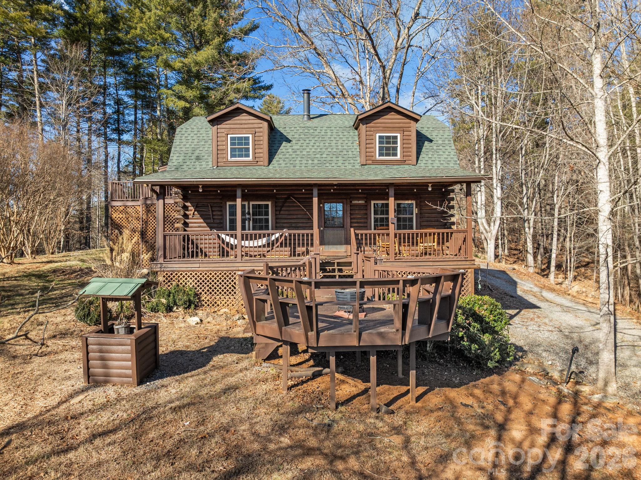 If you’ve been looking for space, privacy, and a true mountain cabin feel, this is it. This home lives like a 4-bedroom with 2.5 bathrooms, offering flexibility for a variety of living arrangements.

Set on approximately 0.9 acres just outside Weaverville, this log cabin offers a comfortable blend of indoor space and outdoor living. The main level features a kitchen connected to the dining area, a spacious living room with a wood-burning stove, a primary suite, and a laundry room, all on one level for easy day-to-day living.

Upstairs are three additional bedrooms plus a large bonus-style room, each with closets, providing flexibility for additional sleeping space, a home office, or recreation.

The outdoor spaces are designed to be enjoyed. A front deck captures mountain views, while the back porch is ideal for grilling, entertaining, or relaxing in a hot tub. The setting offers a sense of privacy while still being manageable in size.

An unfinished basement provides plenty of storage or workshop space, adding to the home’s overall functionality.

Conveniently located within a short drive to both Weaverville and Asheville, this property offers the charm of a log cabin with space to spread out and enjoy the surrounding mountain setting.