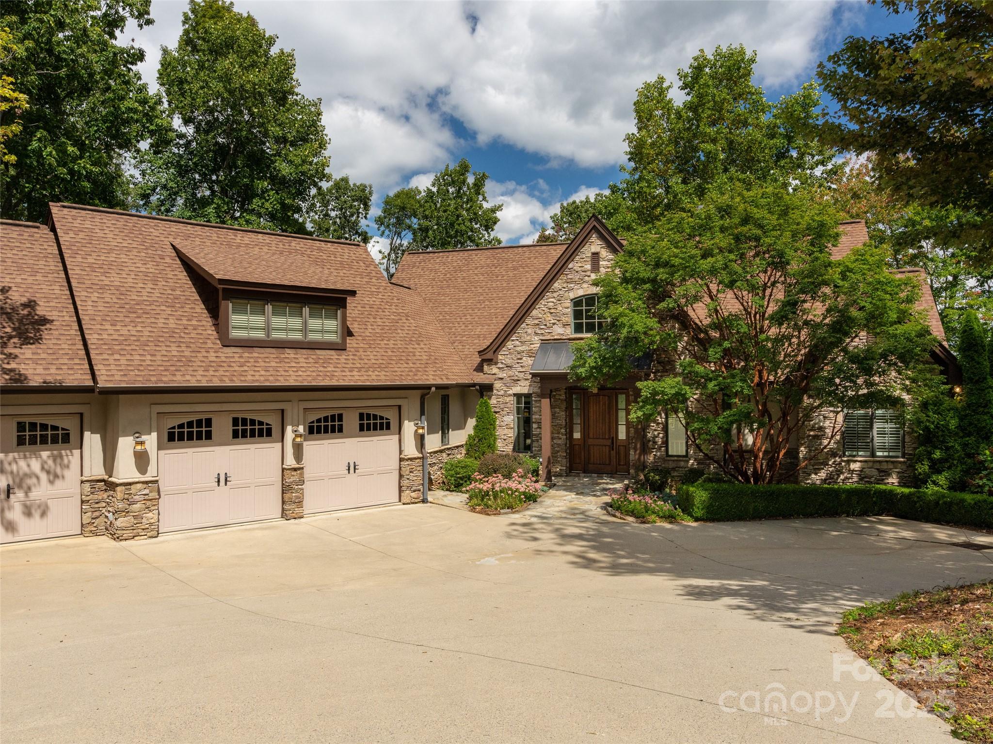 Tucked within the prestigious gated community of Poplar Ridge, this stunning custom-built home offers the perfect blend of privacy, comfort, and convenience. Surrounded by nature, enjoy peaceful mountain views from not one, but two expansive covered decks or enjoy your evening meal on the screened porch. Step inside to a spacious great room featuring a soaring cathedral ceiling and a dramatic stacked stone fireplace. The gourmet kitchen is a chef’s dream, complete with custom cabinetry, an oversized center island, and abundant built-ins for stylish functionality. Gleaming walnut hardwood floors span the entire main level. Expansive primary suite on the main level and three bedrooms on the lower level—one very spacious with a kitchenette. A level driveway leads to a generous 3-car garage, and the beautifully designed outdoor areas are ideal for entertaining. Community amenities include a gated entrance, highspeed internet, cable, playground, and a scenic overlook/recreation area. Ideally located to downtown Asheville and even closer to South Asheville’s top-rated dining, shopping and the regional airport.