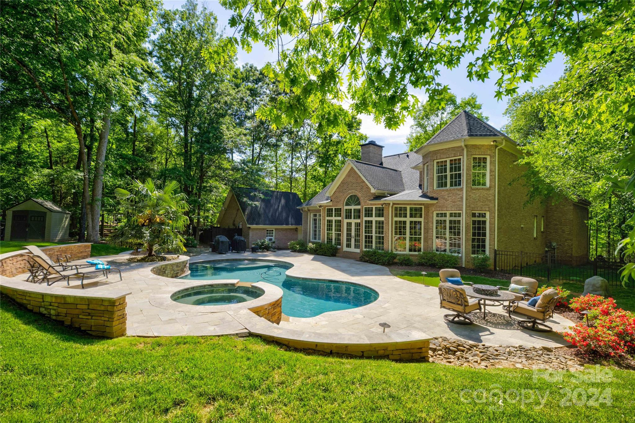 **Thank you for your interest in this beautiful property! Seller is requesting all offers to be submitted by 2 pm on Sunday, April 28, 2024.** Nestled within a serene neighborhood, this exquisite real estate gem embodies the epitome of luxury living. The all-brick exterior exudes timeless elegance and durability, showcasing the craftsmanship that defines this meticulously maintained home. Situated on a sprawling, fenced lot, privacy abounds, offering a tranquil retreat from the bustling world outside. A sunroom beckons with its panoramic views of the lush landscape and inviting inground pool accompanied by a soothing hot tub. Step inside to discover a haven of modern comfort and style, where the updated primary bathroom and kitchen seamlessly blend sophistication with functionality. For the car enthusiast or those seeking ample storage space, a rare find awaits with two expansive two-car garages, providing ample room for vehicles, tools, and recreational equipment.