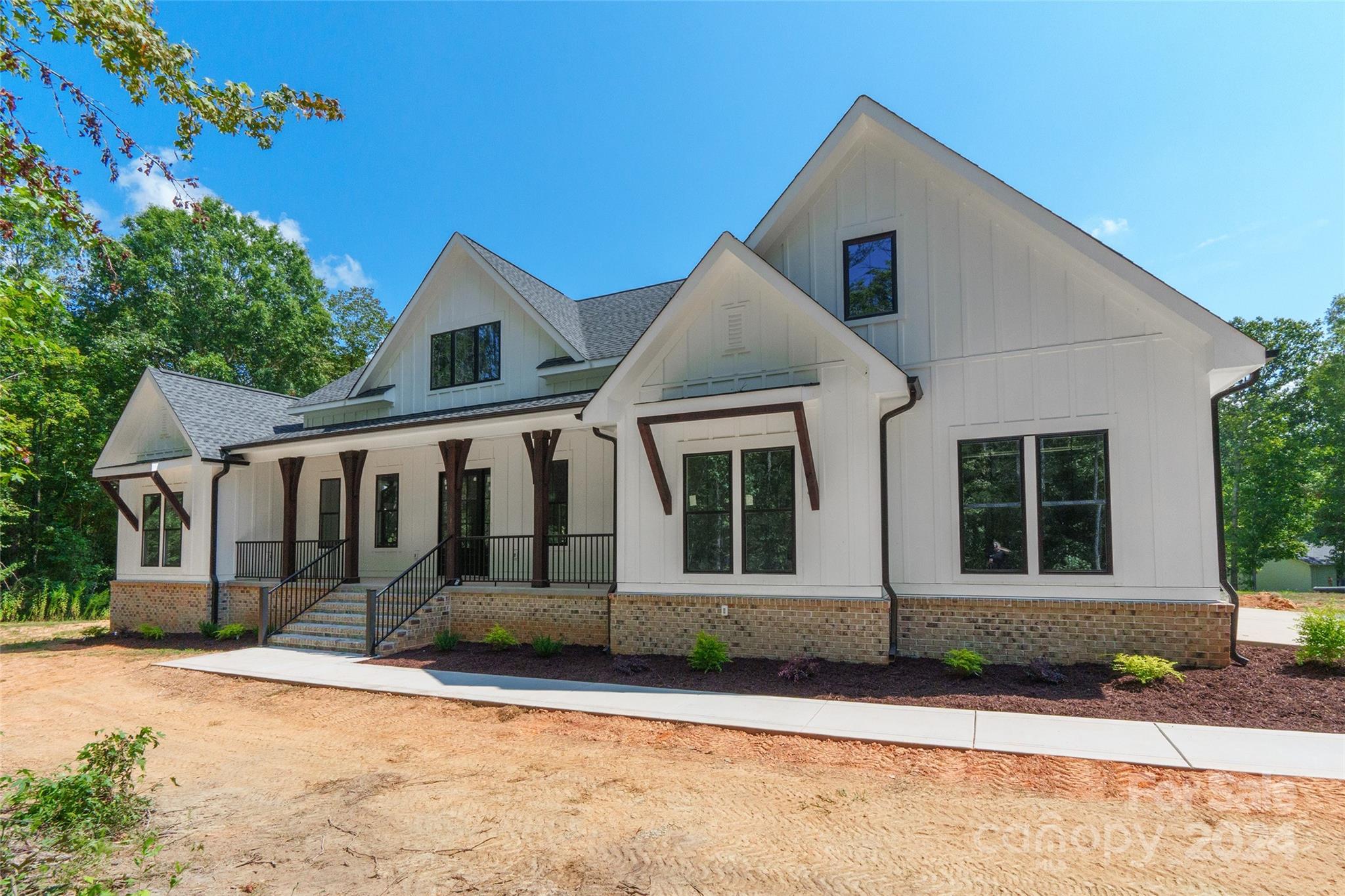 This stunning new construction nestled on 4 acres boasts a charming covered front porch. With 4 bedrooms and 2.5 baths, this spacious home offers versatile living options. The 4th bedroom can easily serve as an office, while a bonus room on the upper level, complete w/ a closet, provides the flexibility to be used as a 5th bedroom. The main living areas feature vinyl plank flooring, leading you to a kitchen equipped w/ an island, pantry, granite countertops, and SS appliances. The primary bdrm features tray ceilings and an ensuite bathroom with a dual vanity & a garden tub. The convenience continues w/ a laundry room that connects directly to the primary through a walk-in closet. The unfinished walk-out basement offers endless potential for additional living space. Enjoy outdoor living on the upper level covered porch or patio on the lower level. Enjoy the comfort of 2 HVAC units. And the best part? No HOA! This home is perfect for those seeking space & comfort in a beautiful setting.