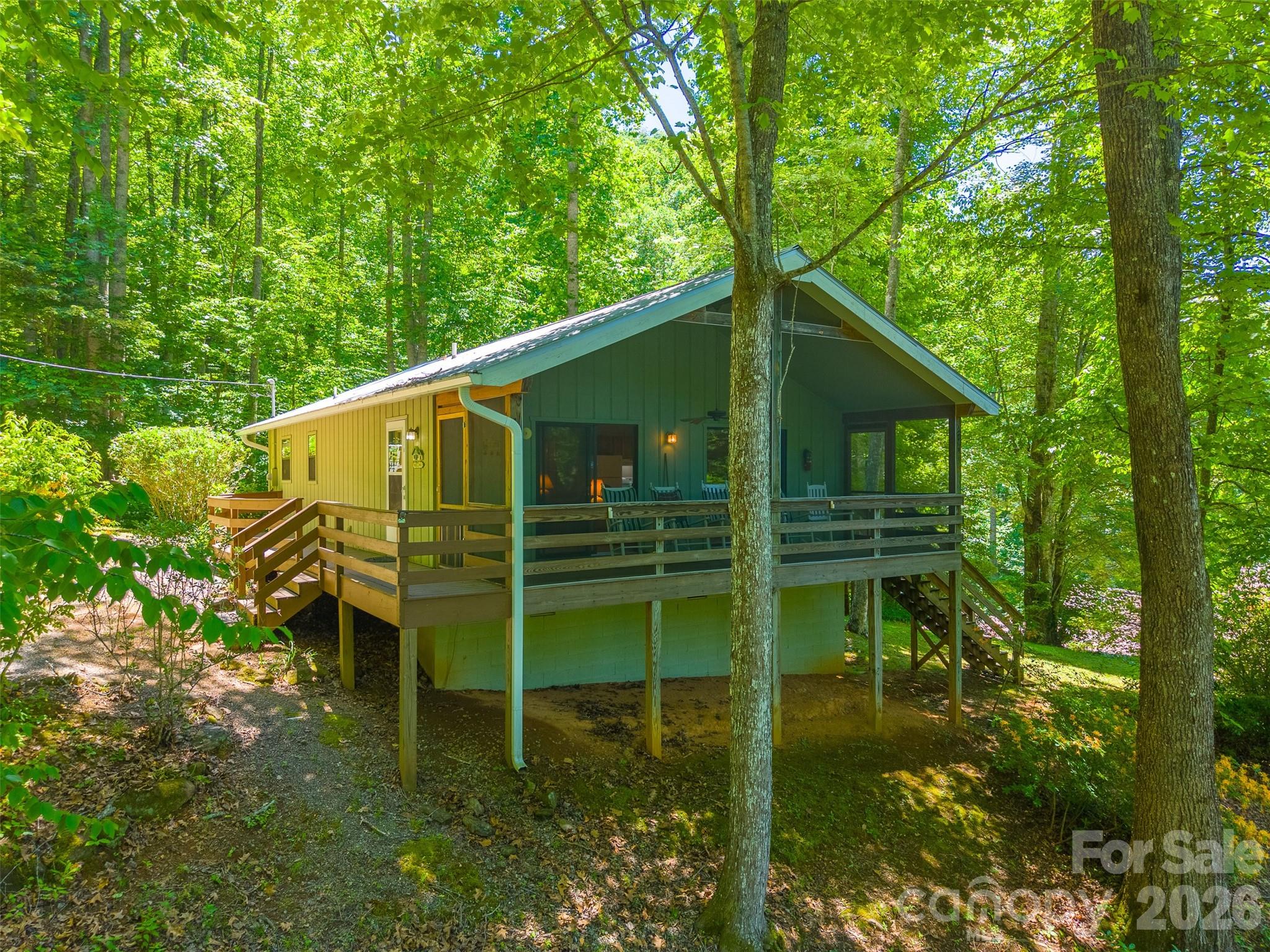 Escape to the mountains of Western North Carolina. Tucked away in a peaceful setting, yet just 15 minutes from town, this charming 2 bedroom, 2 bath home offers the ideal balance of privacy and convenience.  Start your mornings on the screened in front porch, where you can sip your coffee while taking in the cool mountain air and surrounding mountain views. Inside, the open concept living, dining, and kitchen area creates a warm and welcoming space for gathering with family and friends. A cozy gas fireplace serves as the heart of the home, making it the perfect place to relax after a day of exploring the mountains.  Both bedrooms are generously sized, including a comfortable primary suite with its own private bath. This mountain cabin was thoughtfully designed to maximize comfort and functionality without sacrificing charm.  Whether you're searching for a full time residence, a mountain getaway, or an investment property, this inviting home offers everything you need to enjoy the beauty and tranquility of Western North Carolina.