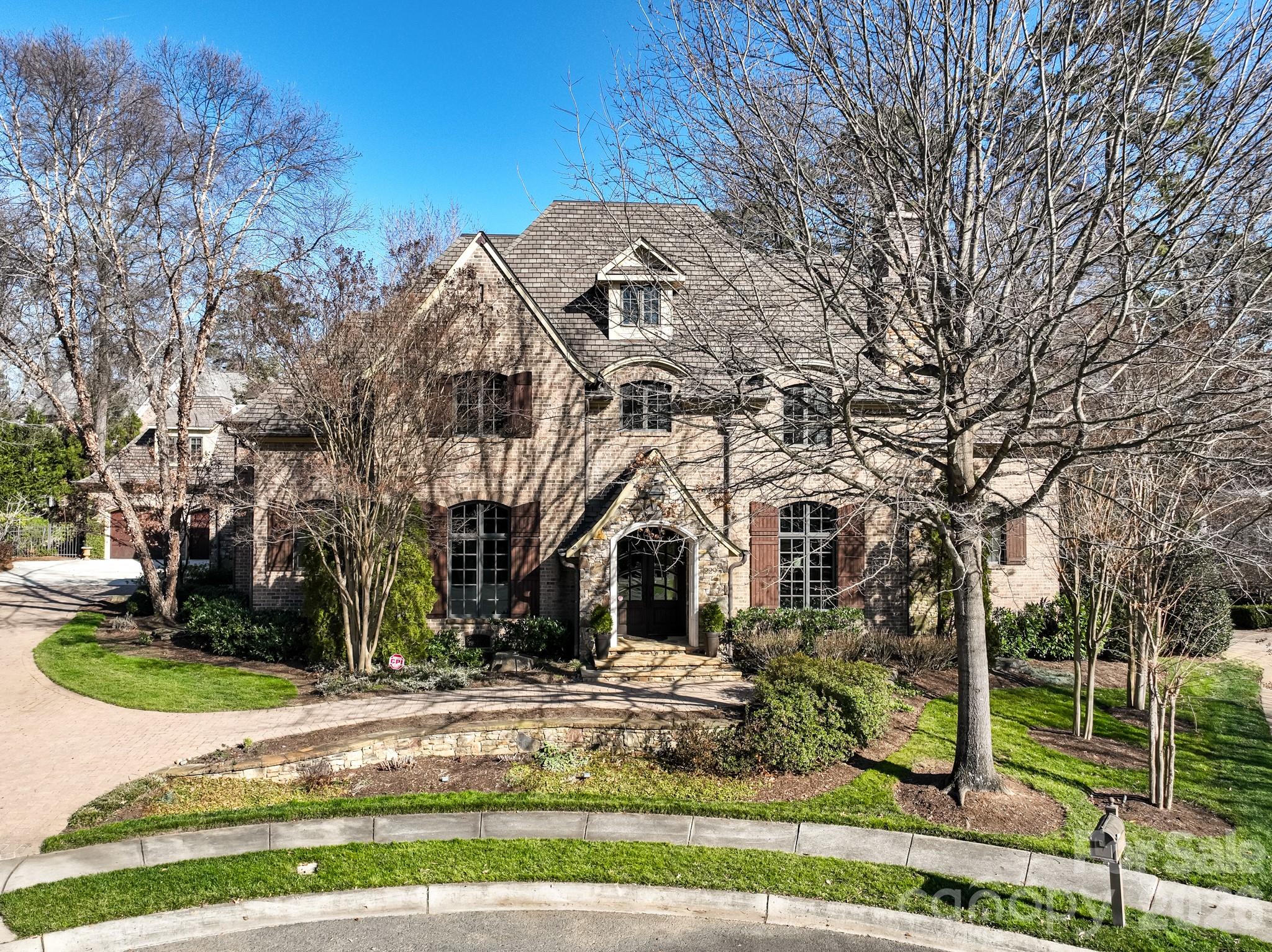 Welcome to this masterfully designed Frank Smith home that blends timeless architecture with exceptional modern luxury. Thoughtfully crafted for both elegant entertaining and everyday comfort, this residence showcases refined finishes, impeccable attention to detail, and versatile living spaces throughout.
At the heart of the home is a gourmet kitchen, designed for the serious cook, complemented by a fully equipped scullery —perfect for hosting, catering, or seamless organization. Showcase your collection in the impressive 900 bottle, climate controlled wine room! The adjacent great room offers an inviting gathering space filled with natural light and effortless flow. The main-level primary suite is a private retreat, featuring a spa-like bath with heated tile floors, luxurious fixtures, and a calming, resort-style ambiance. Additional main-level conveniences include a beautifully appointed study, a laundry room with custom cabinetry, and a thoughtfully designed kids’ study/craft room. Entertain with ease in the media room, stay active in the exercise room. A whole-house generator provides peace of mind year-round. The detached garage includes a finished room above, ideal for guest quarters, a private office, or second living space. Outdoors, the professionally landscaped yard creates a serene setting for relaxation and entertaining, completing this exceptional property. 229 Wrenwood Lane offers a rare combination of architectural pedigree, luxury amenities, and functional design—an extraordinary place to call home.