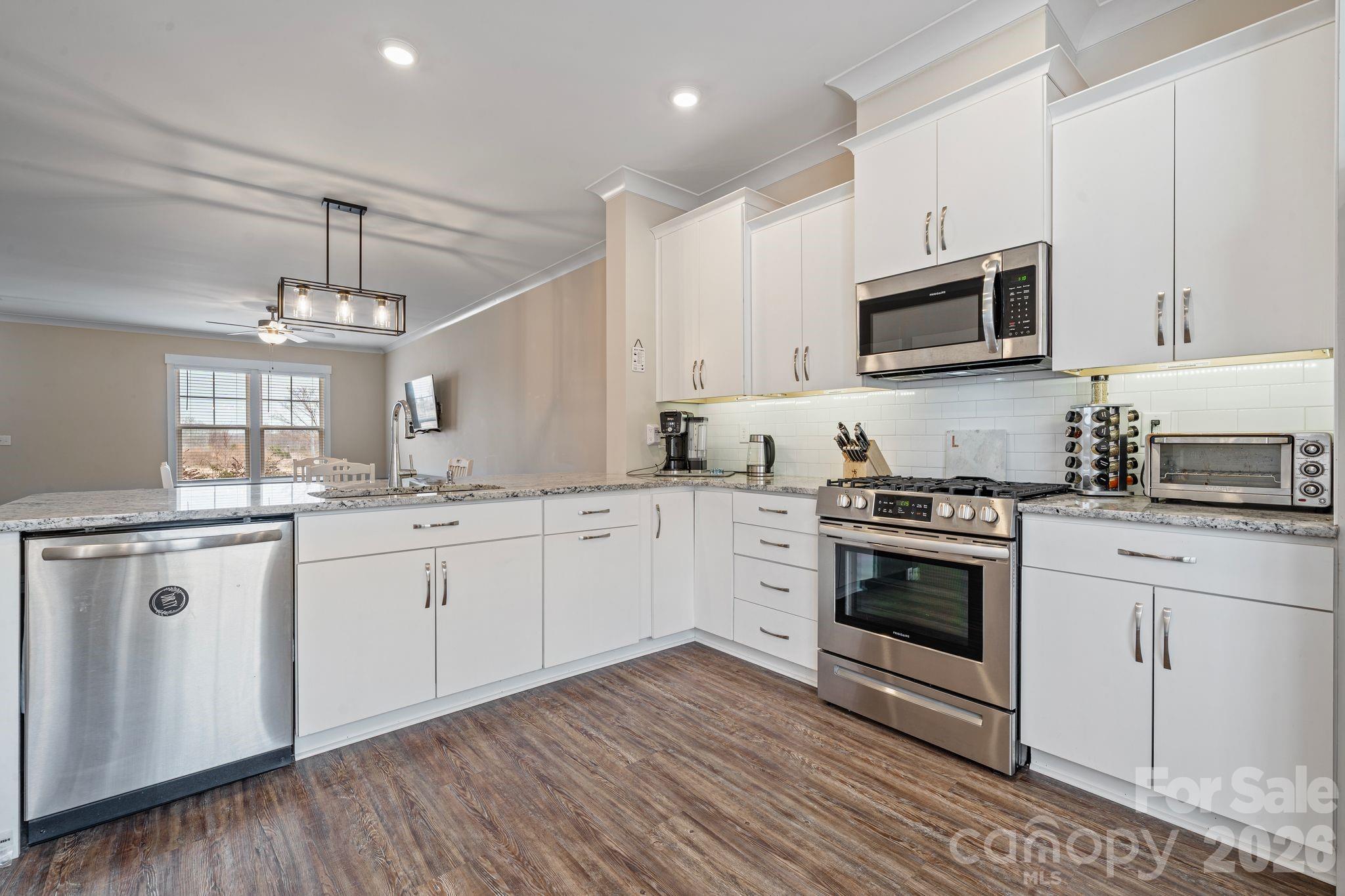 Set in the highly sought-after, family friendly Riverwalk neighborhood, this isn’t just a home, it’s where life starts to feel easier. From the moment you walk in, natural light fills the open floor plan, revealing 3 bedrooms and 2.5 baths designed to give you space without wasting it. The kitchen naturally becomes the place people gather, with granite countertops, a 5-burner gas stove, stylish backsplash, under-counter lighting, and room to cook, connect, and entertain without trying too hard. Luxury plank flooring runs through the main living areas, offering a modern look that’s built for real life, not just for show. Storage is plentiful, the detached oversized backload garage adds both function and curb appeal, and the back patio invites slow mornings with coffee and relaxed evenings that turn into conversations. Step outside and you’ll notice extra-wide sidewalks, lighted streets, and a community designed for walking, biking, and actually enjoying where you live. With resort-style amenities including a lazy river pool, clubhouse, kayak launch, scenic river trails, playgrounds, sports fields, fitness center, grocery store, and waterfront dining at The Pump House. Everything you need is already here… exactly where you’d want it!
